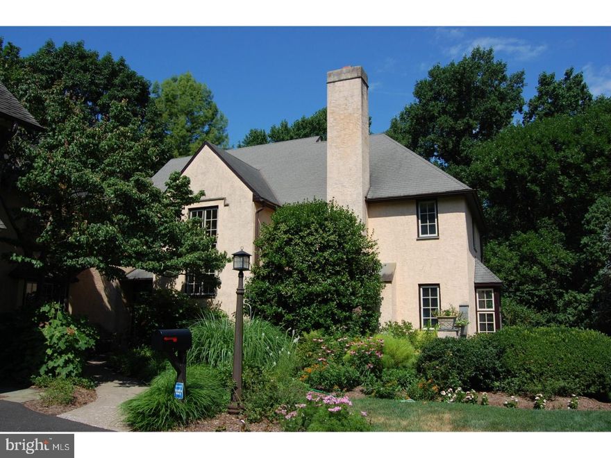 Enjoy gorgeous views of the woods from the deck, the patio, and many windows of this stunning, well-built, architect-designed home, constructed of stucco over masonry (not wood frame). This special property incorporates a 2-story stone carriage house that once housed the heating system for the greenhouses of the historic Druim Moir estate.  The newer section of the home, built in 1988, was designed to reflect the Cotswold style of many early-20th Century Chestnut Hill homes, successfully blending modern and traditional style, with abundant light, beautiful oak floors, and lovely mill work.   Notable features include a 2-story entrance hall, step-down living room with fireplace, first-floor family room with fireplace, updated eat-in-kitchen, spacious master suite with 2 closets and fabulous marble bath, and a wonderful finished, walk-out basement with game, media & craft rooms.  A bonus in-law suite has a 2-story great room with fireplace & cathedral ceiling, bedroom, kitchen, full bath and upper level loft, and is accessible from the second floor of the main house or via back stairs, and also has its own outside entrance.  Druim Moir was the home of Henry Houston, the visionary entrepreneur who developed Chestnut Hill in the 1880s.  When threatened with demolition and dense development in the 1970s, Houston's descendants created a wonderful alternative:  a carefully planned community that includes the original mansion, another smaller Victorian home, 15 new homes, and 10 acres of preserved open space on 20 beautifully landscaped  acres bordering Fairmount Park.
