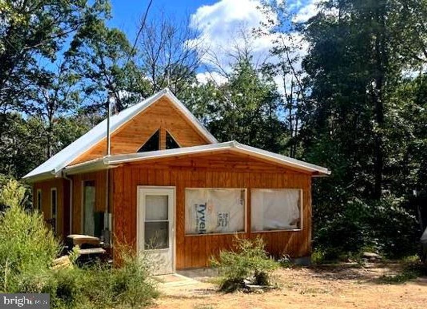 YOU HAVE CHOICES!!  PURCHASE THE CABIN AS-IS FOR $80,000, OR SELLER COMPLETES THE CABIN AT $149,900. TAKE TIME TO RELAX ON 2+ UNRESTRICTED, WOODED ACRES WITH YEAR-ROUND GUSHING SPRING WATER, WHICH FEEDS INTO THE UNFINISHED STICK-BUILT CABIN! THE METAL FOOF NOW HAS DOWNSPOUTS AND GUTTERS.  THE NEW ELECTRICAL PANEL IS NOW INSTALLED. THERE'S A BEDROOM IS ON THE MAIN LEVEL, ADJOINING THE RESTROOM. THE STEPS TAKE YOU UP TO THE LOFT AREA WHICH OVERLOOKS THE MAIN LEVEL AND COULD USED FOR AN ADDITIONAL BUNKING AREA. THE BATHROOM NEEDS SOME FINISHING AND JUST INSTLALLED A TUB.  THE ROUGHED-IN KITHCEN AREA HAS A STOVE, SMALL REFRIGERATOR, AND SOME CABINETS.  THE SPACIOUS LIVING ROOM HAS 2 OVERSIZED FRONT WINDOWS AND THERE'S THE OPTION TO INSTALL A WOODBURNING OR GAS FIREPLACE.  FALCONWOOD IS A QUAINT SUBDIVISION JUST OFF OF RT. 29 N.  THE CABIN LEAVES PLENTY OF OPTIONS TO COMPLETE THE INTERIORS AND MAKE IT YOUR OWN. RECENTLY, THE ELECTRIC SERVICE HAS BEEN COMPLETED. THE METAL ROOF NOW HAS GUTTERS AND DOWNSPOUTS.  THE BLOCK FOUNDATION IS BEING FILLED WITH POURED CONCRETE.  UNDERNEATH THE BACK OF THE CABIN ARE 2 LARGE STORAGE SPACES, WHICH HOUSE THE NEW WELL PUMP, WITH ELECTRIC AND LOCKED DOORS.   RECENTLY INSTALLED IS THE SEPTIC, WHICH IS SUITABLE FOR 3 BEDROOMS.  FALCONWOOD IS A QUAINT SUBDIVISION!  EASY DRIVE TO CUMBERLAND, CAPON BRIDGE AND SURROUNGING AREAS! PERFECT FOR A WEEKEND GET-AWAY OR MAKE IT YOUR NEW HOME!