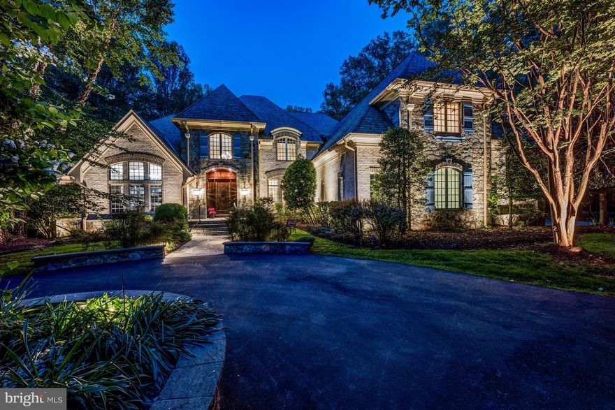 Welcome to this exquisite French Country estate, custom built and perfectly situated on 3.5 private, beautifully landscaped acres. A grand circular driveway sets the tone as you arrive at this elegant retreat. Step inside to a dramatic two-story foyer with a sweeping curved staircase, leading into a breathtaking great room featuring soaring ceilings, floor-to-ceiling windows, and a stunning custom fireplace mantel. The spacious formal dining room connects to a well-appointed butler’s pantry with custom cabinetry and a wine fridge. The chef’s kitchen is a true centerpiece, outfitted with top-of-the-line appliances, a generous center island, bar seating, and a cozy breakfast room. The kitchen flows seamlessly into the two-story family room, showcasing a vaulted, beamed wood ceiling, stone fireplace, and custom built-ins. The main-level owner's suite offers a privacy with vaulted ceilings, a fireplace, morning bar with beverage chiller, and a luxurious spa-inspired bath. Enjoy a jetted soaking tub, a walk-in shower with multiple body sprays, dual vanities, and two expansive walk-in closets with custom built-ins. Upstairs, a charming loft overlooks the family room and provides access to three private en-suite bedrooms and the laundry room. The walk-out lower level is designed for both relaxation and entertaining. You're welcomed by a striking stone niche accent wall, setting the tone for the exceptional spaces ahead, including a wine tasting room, a spacious recreation room with adjoining kitchenette, and a billiard room with a stone fireplace. A fitness room and a beautifully designed spa bath complete this level. Outside, enjoy an expansive deck overlooking the serene, tree-lined grounds, with stairs leading down to a spacious, flat backyard.