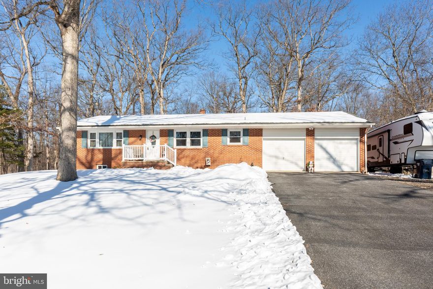 Country roads lead you home to 3820 Kump Station Rd. This charming brick rancher is nestled on a peaceful, partly wooded lot, between Taneytown and Littlestown. Tasteful updates inside blend with the warmth of wood floors that run throughout the home.  Enjoy the best of every season when you relax on 2 level deck on warm days or unwind in the romantic winter igloo on crisp, chilly nights. The home features 3 comfortable bedrooms, 1 bath, a spacious kitchen with a pantry, and a full unfinished basement.  A 2‑car garage, paved driveway, and dedicated RV parking pad add convenience and flexibility for additional parking. Check out the additional photos that the owner provided of the warmer weather so you can appreciate the back yard.  You won't be able to fully appreciate the beauty of this lot under the snow.  Grab your coat, hats, gloves and snow boots for a full tour of this lovely property.