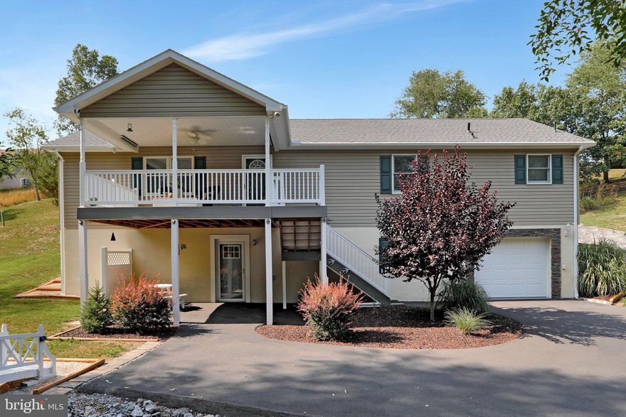 Welcome to your private retreat located minutes to Berkeley Springs and I-70!!!This stunning Property features Hardwood flooring throughout a light filled open layout. The Main level Living Room has custom built ins, a Gourmet Kitchen with breakfast bar and stainless appliances and adjoining Dining Room area perfect for gathering with Family or Guests. Primary Owner's Suite with sitting area and attached luxury bath. 2 Nicely appointed Junior Bedrooms share a full bath. Lower Level offers even more entertainment space with spacious Recreation Room, Game Room, Den with pellet stove for those chilly fall evenings, and a 1 car garage with large workshop area! Although located within a community, the outdoor space offers a peaceful private setting with 2 trex decks- a 10x20 off of the dining area and a 12x10 covered overlooking trees. Plenty of additional parking includes a 2 car covered carport area and paved driveway. Whole home attic fan is controlled by thermostat. Upgraded LED lighting throughout. Berkeley Springs is a popular visitor destination offering shopping, dining, and numerous spas! *High Speed internet available*