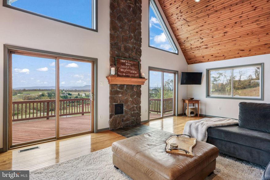 Wake to panoramic Shenandoah Valley views from this stunning chalet-style home on five private acres. Designed as an organic homestead, it features a thriving permaculture garden, orchard, and chicken coop for sustainable living. Enjoy immediate income from a fully furnished Airbnb/in-law suite that has generated steady revenue while giving guests their own private mountain retreat.

 

Natural light pours through floor-to-ceiling windows, highlighting vaulted pine ceilings and gleaming hardwood floors. Step through double sliding doors onto a wraparound deck—perfect for entertaining or quiet mornings watching the sunrise. The remodeled chef’s kitchen features custom soft-close cabinetry by Shenandoah Woodworks, granite counters, stainless appliances, and walk-in pantry.

 

The main-level primary suite offers a spa-like retreat with a jetted tub, walk-in closet, and mountain views. Upstairs are three additional bedrooms and a full bath, with abundant walk-in closets and storage throughout the home.

 

The walk-out basement functions as a flexible in-law suite or proven Airbnb, earning nearly $18,000 in the past year. Sold fully furnished, it’s a turnkey opportunity for the next owner. This level also includes a beautifully designed art/pottery studio that could easily convert into another bedroom to boost rental potential.

 

A two-car garage, level RV parking spot, and newly graveled driveway provide ample parking for residents and guests. High-speed fiber internet supports remote work, making this stunning property a combination of serene country living with modern comfort and accessibility.

 

Recent updates include a new garden deer fence (2024), basement flooring and second kitchen (2023), 80-gallon commercial water heater (2021), gas furnace (2018), and 12x24 storage shed (2017).