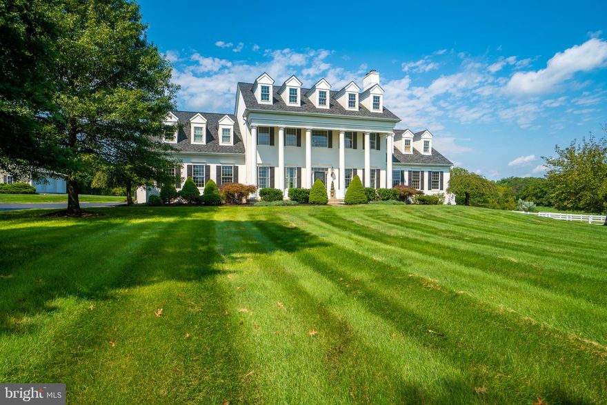 Welcome to Whitegate, an exceptional 8-acre property with endless possibilities. This stunning 6 bedroom, 5.5 bathroom, 6,183 square foot home boasts a huge family room with a wall of windows that extend two stories high, a dramatic two-story stone gas fireplace, and breathtaking views of the beautiful surroundings. The chef's dream kitchen features granite countertops, a Thermador professional range and hood, stainless steel GE double oven, Sub Zero fridge, and warming oven, with views of the serene outdoors. The upstairs offers four generously sized bedrooms and three full baths. There is a large "in-law suite" on the first floor with 2 bedrooms, full bathroom, living room and kitchen with a separate entrance and access to the back patio. The lower level is an entertainer's dream, complete with a full movie theater with two-tier theater seats, a bar with a full-size refrigerator, sink, and dishwasher, and plenty of space for a full-size pool table. The unfinished basement space recently saw the addition of a golf simulator. It has been constructed and wired for a projector.  The next owner can paint and add carpeting to their liking or covert the space to a huge arts and crafts area or playroom. In addition to the three attached garage spaces, the property features a detached, oversized garage that is every car mechanics dream work space! It is equipped  with a hydraulic car lift and plenty of space to store equipment, tools and more!
Outside, a 4-stall barn features a heated tack room with a washing machine, hot water wash stall, a run-in with adjoining paddock plus a lighted riding ring. The 2 separate pastures, each 2 acres with auto waterer, are enclosed by stunning white fences. In addition, the lighted riding ring has its own drainage system, providing a mud-free surface for outdoor activities. The property also features a detached three-car garage that will impress any car enthusiast. The garage includes a professional hydraulic auto lift and a full-size compressor with piped air outlets throughout the shop, making it a perfect space for car maintenance, woodworking, or other hobbies.   The listing includes the 4.1 acres with the house and barn and the additional lot with  4 acres of pasture. Whitegate is truly a magnificent property that must be seen! Schedule an appointment today!