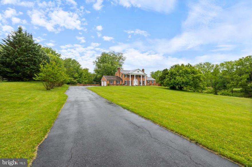 Back on Market Step into this meticulously maintained all brick colonial, where elegance meets functionality. Home boasts a spacious a bright entry foyer that leads into the living room, featuring a wood burning fireplace—perfect for cozy evenings and gatherings. Gleaming hardwood floors throughout add warmth and style. The heart of this home is the renovated kitchen and breakfast room. Whether you’re hosting guests or enjoying a quiet morning, this space is designed for both function and beauty. A main-level bedroom suite provides flexibility and could easily serve as an additional bedroom or home office, with a full bath making this home adaptable to your needs. Step outside onto the large patio, ideal for outdoor relaxation, and enjoy serene views of the3+ acres giving you both privacy and natural beauty. For even more outdoor enjoyment, a patio from the basement level is perfect for evening relaxation or entertaining. Upstairs you will find a spacious primary suite with sitting area and expansive bathroom with separate shower and soaking tub. This level also includes 3 additional bedrooms and shared hall bath. The fully finished basement is an entertainer’s dream, featuring an expansive brick bar and a huge recreation area—ideal for movie nights, sports events, or hosting friends and family. Additionally, there is a bonus room that offers even more flexibility for a home gym, playroom, or additional storage. Don’t miss the opportunity to make this rare gem your own!