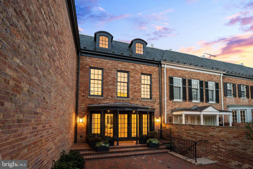 Nestled on Georgetown's most private street in the coveted East Village, this stunning townhome is the perfect blend of Washingtonian elegance and modern living. The five-bedroom, five and a half bath home is newly renovated by renowned architect Christian Zapatka and OC Builders. Upon entry through the gated driveway, the luxurious open concept main level, with interiors by Azali Kassum Design, features a light-filled foyer with white oak chevron flooring, a custom marble fireplace surround, hidden built-in bar and a wall of French doors providing access to the private rear garden. The gorgeous gourmet kitchen features Snaidero Italian cabinetry and Miele appliances. Each of the five bedrooms has its own en suite bathroom with Waterworks fixtures, Lacava soaking tubs and gleaming white Thassos marble floors. Designer fixtures from Circa Lighting and Arteriors illuminate the home along with recessed lighting throughout. The upper two levels provide privacy and comfort; a terrace with skylight, custom closets and oversized windows. The lower level with separate entrance features a spacious living space, second custom Snaidero kitchen and private bedroom with en suite bathroom, making this the ideal guest haven. A custom elevator providing access to all 4 levels, new HVAC, water heaters, electrical and plumbing, along with upper and lower-level laundry and linen storage, new windows and doors make this a truly rare product in Georgetown. This turn-key property is equipped with every modern amenity while being steps from coveted restaurants and retail and all the unparalleled charm that Georgetown has to offer.