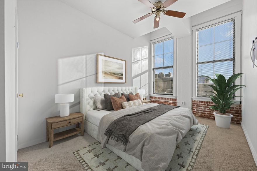 ​Welcome to this charming 2 bedroom, 2 bathroom condo located in the heart of Old City, Philadelphia.
As you enter, you are immediately greeted by exposed brick that showcases the historic character of the building. Natural light fills the space, highlighting the open layout, beautiful hardwood floors, and tall ceilings, which make the condo feel extra spacious. The kitchen was updated in 2020 and features quartz countertops, new stainless steel appliances, and re​painted cabinetry. A window over the sink overlooks the living and dining area and creates the perfect nook for barstool seating, offering both functionality and connection to the main living space. Off the kitchen, the dining and living areas flow seamlessly, making it ideal for entertaining or everyday living. As you enter the primary suite, a built-in custom shelving unit provides a perfect spot for decorative accents or extra storage. The spacious room includes a beautifully renovated bathroom, completed in Fall 2021, featuring a mosaic tile floor, stone pebble tub floor, and porcelain tile shower walls. The closet is generously sized, offering ample space for clothing and personal items. The second bedroom is also spacious, perfect for a guest room, roommate, or home office. A second full bathroom off the hallway provides convenient access for guests. Additional features include an in-unit washer and dryer, a WiFi-enabled thermostat, and a private storage unit already included in the condo fee. The storage space is approximately 2 x 5, ideal for seasonal decor, luggage, or extra household items. The home also includes one deeded parking spot, providing everyday convenience in this sought-after Old City location. Residents enjoy access to a reservable rooftop deck, perfect for entertaining, working from home, or enjoying skyline views. The building also offers 24/7 concierge, on-site management, a gated courtyard with grills, a secure parking lot, and a convenient package center with door delivery or easy pickup. With a little fresh paint and your personal touches, this home presents a wonderful opportunity to customize and add value. For added peace of mind, the AC system, hot water heater and roof were all replaced in 2025. Bridgeview Place is situated on a quiet cobblestone street in the heart of Old City, within walking distance to cafes, restaurants, galleries, and more. It’s also perfect for commuters, with easy access to bridges, highways, and public transportation.