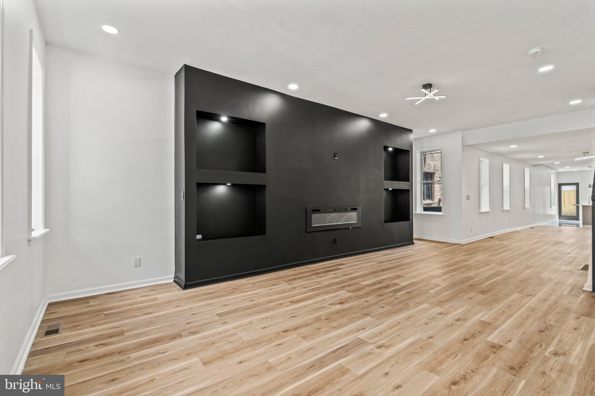 Welcome to your dream home in the heart of Point Breeze! This newly renovated 3-story gem boasts 5 spacious bedrooms, 2 luxurious baths, and over 3,000 sq ft of refined living space. Step into an expansive open-concept first floor featuring wide-plank grey-brown flooring, recessed lighting, and abundant natural light. The stunning custom entertainment wall—with built-in illuminated shelving and electric fireplace—is perfect for cozy nights or stylish hosting. The chef’s kitchen is straight out of HGTV, showcasing soft-close beige cabinetry, white quartz counters, stainless steel appliances, and an eye-catching hexagon glass backsplash. It flows seamlessly into a large, fenced backyard—ideal for entertaining and summer BBQs.
The second floor offers 4 generously sized bedrooms, a sleek modern bathroom with designer tile, and a full laundry room for ultimate convenience. The private third-floor primary suite is a true retreat, complete with dual walk-in closets and a spa-like bath featuring a barn door entry, walk-in shower, and LED Bluetooth mirror. A fully finished basement provides flexible space for an office, gym, playroom, or media lounge. Additional upgrades include new electric, plumbing, dual-zone HVAC, modern iron railings, and central A/C. Just minutes from Center City’s dining, shopping, and nightlife—this rare find won’t last. Schedule your showing today!