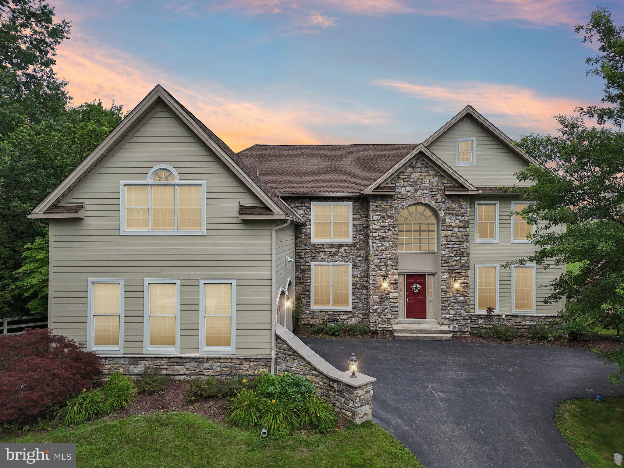 Welcome to this exclusive style home that is one of only three built in the community, where space abounds with an ideal and thoughtful floorplan in the ever desirable and highly sought-after Reserve at Eagle! This well-maintained and move-in ready home offers the perfect blend of elegance, comfort, and functionality across three finished levels. Enter into a grand two-story foyer where the sweeping curved staircase sets an impressive tone. Flanked by a living room on one side and a private home office with French doors and custom built-in shelving on the other, the entrance creates an ideal balance between sophistication and practical living spaces. The bright, eat-in kitchen is a chef’s delight, featuring beautiful custom maple cabinetry, granite countertops, a large island with seating, a walk-in pantry, and a sunny breakfast room. There are two sets of glass doors that lead to the oversized deck, one in the kitchen and one the great room, making it perfect for entertaining. The deck overlooks a flat, tree-lined backyard offering privacy and space for outdoor enjoyment. Soaring two-story ceilings and a dramatic wall of windows fill the great room with natural light, anchored by a floor-to-ceiling stone wood-burning fireplace that adds warmth and character. A formal dining room, convenient half bath, laundry room, and access to the oversized two-car garage complete the well-appointed main level. Ascend to the second floor by either the front or back staircase, where you will find the expansive primary suite offering a luxurious retreat with tray ceilings, a spacious sitting room with custom built-ins (ideal for a second office or reading nook), two walk-in closets, and a large ensuite bathroom featuring a soaking tub, walk-in shower, dual vanities, and a dedicated makeup station. Three additional bedrooms, two sharing a Jack and Jill bathroom and one with its own full bath, each feature walk-in closets providing ample storage and comfort for family or guests. The fully finished walk-out basement expands your living space with a massive recreation room, a game or theatre room, and a fifth bedroom perfect for guests or extended family, along with a convenient half bath. Additional features include a brand new HVAC units (downstairs main unit and upstairs unit), new gas hot water heater, new cooktop, new washer, new dishwasher, and custom wood shutters. Enjoy all the amenities of The Reserve at Eagle, including a community clubhouse, sparkling pool, and playground, all nestled in a peaceful, beautifully maintained neighborhood in the highly sought-after Downingtown Area East Schools!
