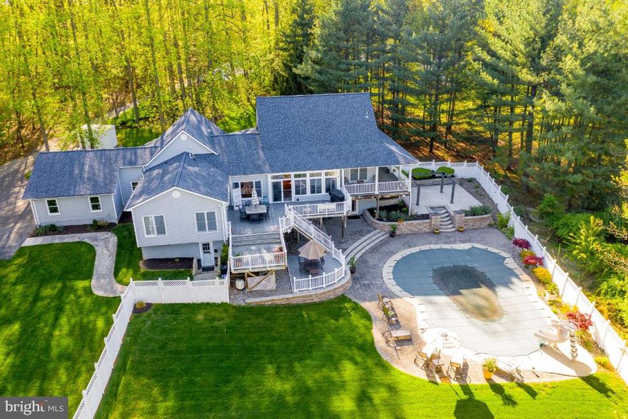 What an incredibly rare find. Over 4000 SF quietly situated on 4+ acres in upper Montgomery County. As you exit the main road and drive down the driveway you feel as if you're being transported into a serene country setting. Pulling up you're immediately struck by the beautiful landscaping and the flower-lined porch that wraps the entire home.  Entering introduces a wide-open floor plan with beautiful hardwood floors and soaring ceilings. You'll notice clear views through the home into your beautiful outdoor space in the backyard. The main level features a first-floor master suite, gourmet kitchen, fully equipped gym, equipment to stay, as well as a large office space. As you head downstairs you walk into an entertainer's dream! There is a fully built-in bar, a pool table (that stays), and a wide-open space that walks out onto the pool deck. The back yard boasts a multi-leveled deck and patio with a pergola and stone pavers pool deck. There is even a very large grassy area inside the fenced area. Just below your three-car garage and around the back of the house there is a fully renovated one-bedroom, one-bathroom income-generating apartment that is currently rented by a young professional. There is so much more to say and see but you will just have to come and experience it for yourself!  Hurry, this one will be popular!