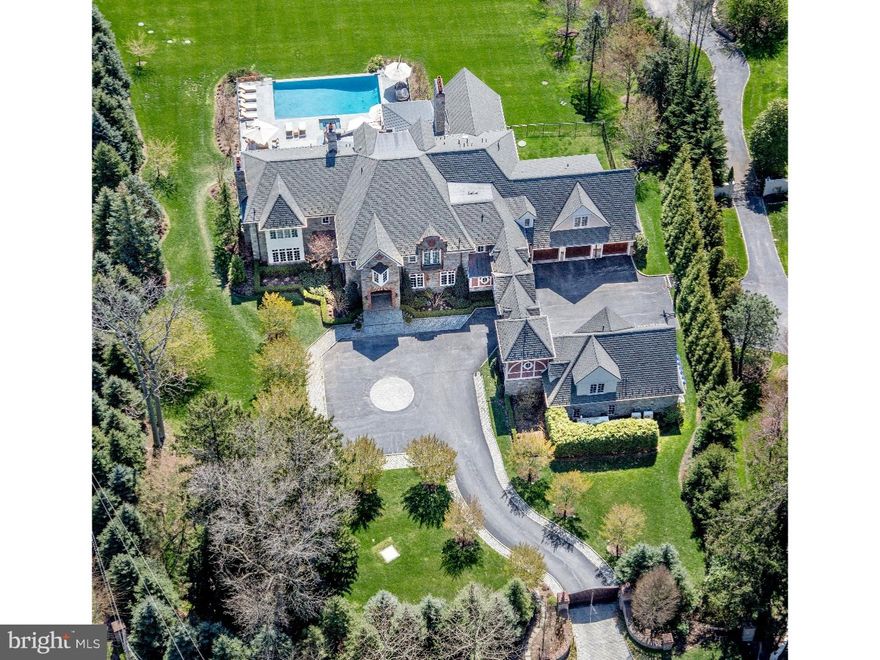 Ringed by mature evergreens, estate fencing, and accessed by tall, hand crafted wood gates,this 8 bedroom, 9 full & 3 half bath stone & brick residence occupying a 2+ acre parcel of prime real estate.  Although only 9 years old, the current owners have re-imagined and renovated each space, elevating the amenities, mechanicals and finishes to a quality rarely found in today's marketplace. Understanding modern buyer's need for both large scale and intimate spaces, the home offers both in multiples. Eye catching iron staircase sweeps to a second level Foyer, a step down Great Room offers captivating multi piece mill work and limestone mantle; elliptical ceiling detail and wide cased openings offer unique style and connection to an elegant formal Dining Room. Spectacular double island Joanne Hudson Kitchen offers unparalleled prep and seated island space while just steps away is a vaulted Family room with trussed faux bois beams, natural stone floor to ceiling fireplace, and three exposures of light. The Breakfast Room connects to a covered outdoor terrace, both offering the focus and warmth of fireplaces. Finished in character grade cherry paneling, the Library is highlighted by a custom desk, shelving, and built-in file cabinets, making this space as handsome as it is functional.   At days end, retreat to an intimate Master Bedroom, reminiscent of a fine European hotel with overlook balcony, fireplace, seating area and deluxe Master Bath.  Automated shades provide requisite privacy for the under window jetted tub.  His and her separate custom vanities, water closets, walk-in outfitted closets and morning kitchen complete this extraordinary space. Five additional Family Bedrooms, each with private baths as well as two bedrooms and two baths over the independent garages provide ideal and expanded family, guest or staff space.  Fully finished walk out to grade LL captivates with a full sized Second Kitchen, Recreation Room with fireplace, Billiard Room, Massage Room with ballet bar, stadium seated Home Theater , Audio Visual Room, Gym with Full bath and secondary laundry and walk-in, thermostatically controlled Wine Room with antique entry door.   Tiered wide stone Terraces enhance the rear of the property and surrounds a glamorous infinity edged pool in resort quality style.    Brilliantly Executed, Flawlessly Presented.