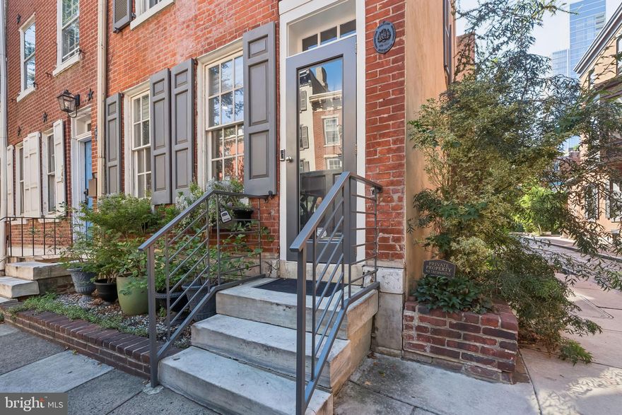 * Seller offering assist towards a rate buydown * Light-filled, corner townhome in Washington Square West underwent a 2017 renovation at 12th & Panama St (near Pine) with parking out your back door in the McCall Catchment. Exposed brick, warm hardwood floors, a stunning stone fireplace and vintage mantel, and a thoughtfully designed contemporary kitchen greet you on the main level. The second level features a primary suite with a spacious walk-in closet, a second fireplace, and a large bathroom with double sinks and heated flooring. The third level offers two bedrooms, both with built-in shelving and large closets, and a second full bath with tub/shower. The fourth level hosts a vaulted great room with built-in shelves and a beverage fridge—ideal as a home office, entertainment space, or 4th bedroom—and a deck with unobstructed city views. Full basement with storage and laundry, a one-car off-street gated parking pad, which doubles as a patio, completes the package of two outdoor spaces. Located steps from Antiques Row, destination restaurants, parks, transit + convenient to Jefferson, Pennsylvania Hospital and Wills Eye. Schedule your showing today!
