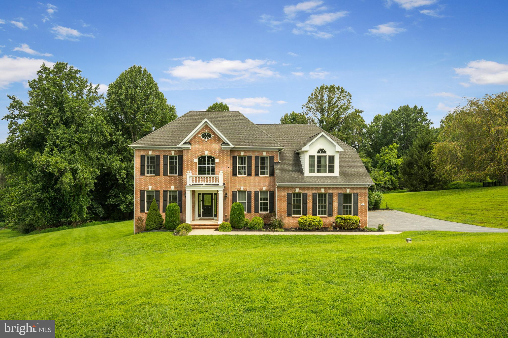 Welcome to 5 Fox Field Court — a stately all-brick colonial nestled at the end of a peaceful cul-de-sac in one of the area’s most serene and scenic neighborhoods. Situated on over 4 meticulously landscaped acres, this beautifully maintained home offers more than 5,000 square feet of thoughtfully updated living space designed for comfort, style, and effortless entertaining. Step into the grand two-story foyer, where sunlight pours in to illuminate the rich hardwood floors and graceful architectural details. To your right, a private home office makes working from home a breeze. To the left, a spacious formal living room sets the tone for elegant gatherings. The heart of the home is the stunning gourmet kitchen, featuring stainless steel appliances, granite countertops, modern gray cabinetry, a chic tile backsplash, and a cozy breakfast area—perfect for casual meals or your morning coffee. Flowing seamlessly from the kitchen is a warm and inviting family room with a classic brick fireplace—ideal for cozy nights in. Host holidays and special occasions in the formal dining room, accented by hardwood flooring, crown molding, and detailed chair rail trim. A convenient half bath and laundry room complete the main level. Upstairs, unwind in the luxurious primary suite, complete with hardwood floors, a gas fireplace, crown molding, dual walk-in closets, and a spa-like ensuite with soaking tub, dual vanities, and a glass-enclosed shower. Three additional generously sized bedrooms—each with plush carpeting—plus two full baths provide ample space for family or guests. The finished lower level offers endless possibilities with a second family room, a large rec space with a custom wet bar, recessed lighting, a bonus room perfect for a guest suite or additional office, a full bath, and plenty of storage. Step outside to your backyard retreat. Enjoy summer BBQs or morning yoga on the newer stone patio, now complete with a brand-new drainage system for enhanced durability and peace of mind. The freshly painted, multi-level deck leads to a large hot tub—an ideal spot to unwind under the stars. Tucked at the back of the property, a tranquil creek adds a touch of nature’s serenity. Car enthusiasts and hobbyists will love the oversized two-car garage, offering additional storage space and convenience, along with ample driveway parking for guests, RVs, or extra vehicles. Notable updates include: deck power washing and painting (2025), well water tank (2024), second-floor AC unit (2024), refrigerator (2023), hot tub (2022), stone patio and landscaping (2021), radon mitigation system (2021), kitchen renovation (2020), new carpet (2020), Generac 16KW generator (2020), and a home alarm system (2020). This is more than just a home—it’s a lifestyle. Don’t miss the opportunity to make this extraordinary property your own!