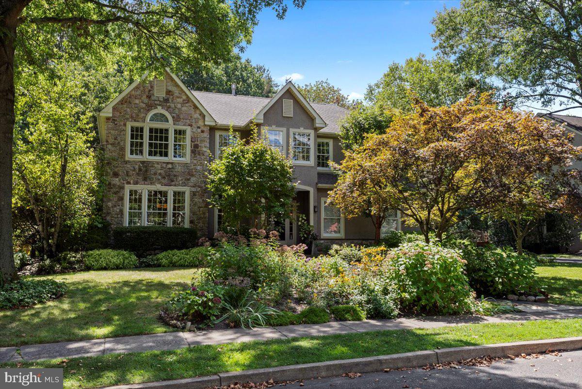 Sophistication. Privacy. Convenience. Once the neighborhood’s model home, this property continues to impress with its refined finishes and lifestyle-driven design. From the moment you step inside, high ceilings, custom millwork, and wooded views create an atmosphere of quiet sophistication. The living room’s cathedral ceiling frames a striking brick fireplace, while hardwood floors and custom trim work flow seamlessly throughout the main level.
The kitchen—styled with maple cabinetry, granite countertops, a center island, and custom storage—pairs new high-end appliances with everyday functionality. The open flow extends to an opulent formal dining room, designed to elevate both everyday meals and special gatherings. A breakfast area with sliders opens directly to the backyard, where resort-style living awaits. Swim in the heated saltwater pool, soak in the hot tub, or relax on the expansive multi-level cedar deck with retractable awning. Professionally landscaped gardens, a stone patio, and even custom-built pool and garden shed make this yard a retreat of its own.
Upstairs, the vaulted primary retreat offers a walk-in closet and spa-inspired bath with jetted tub, dual vanity, and walk-in shower. Three additional bedrooms feature high ceilings, ceiling fans, and ample closets, served by a Carrara marble hall bath. The finished basement adds flexibility with spaces for an office, gym, or guest quarters, complete with kitchenette. Updated systems include a new roof (2024), water heater (2024), and HVAC (2021). With a two-car garage, spacious driveway, Central Bucks schools, and walkable access to SEPTA and downtown Doylestown, this home is a rare blend of sophistication, privacy, and convenience.