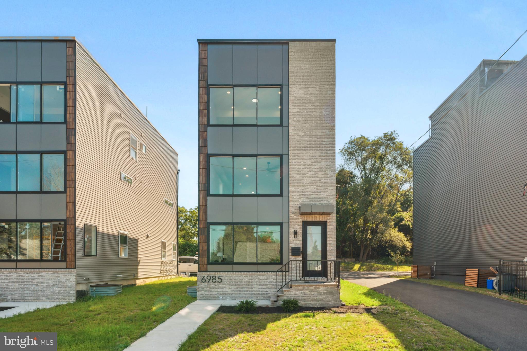 Welcome to a truly stunning new construction townhome located in the vibrant heart of Roxborough. This exceptional single-family residence is a masterpiece of modern design and craftsmanship, offering an unmatched blend of luxury, comfort, and style. With three bedrooms, three and a half bathrooms, and a one-car garage, this home is perfect for discerning buyers seeking an elegant urban lifestyle. As you enter, you'll immediately notice the soaring ceilings and an abundance of natural light that beautifully illuminates the natural maple hardwood floors that flow throughout the home. The spacious living room is a showpiece of contemporary design, featuring a chic electric fireplace and a sophisticated wet bar, ideal for entertaining guests. The main level also includes a convenient powder room, a laundry area with a built-in sink and stunning countertops, and access to both the one-car garage and the backyard. Ascending the unique maple staircase, crafted from reclaimed barn wood, you will be awe-struck by the expansive open floor plan on the next level. The dining area seamlessly transitions into a gourmet kitchen, a culinary delight equipped with Level 9 quartzite countertops, state-of-the-art Thor stainless steel appliances, and a six-burner stove. The centerpiece of the kitchen is a striking center island with waterfall countertops and an additional wet bar area. The expansive 8-foot by 9-foot sliding doors flood the space with light and offer the option for a custom deck, with choices for wood or Trex decking available post-settlement. On the upper level, you'll find more of the beautiful natural maple hardwood flooring leading you to the serene sleeping quarters. The primary suite is a tranquil retreat, featuring large windows that invite an abundance of natural light, a spacious walk-in closet, and a luxurious en-suite bathroom. The en-suite is a true spa-like experience, boasting a double sink vanity and an oversized walk-in shower that is sure to impress. An additional bedroom on this level also includes a private en-suite bathroom, providing comfort and convenience for guests or family members. The highlight of the home is the expansive 41x17 rooftop deck, offering breathtaking views of the city skyline. This space is perfect for hosting gatherings, enjoying a quiet evening under the stars, or simply soaking in the panoramic views. The lower level of the home features a third bedroom with an attached bathroom, finished to the same high standards as the rest of the home. This versatile space is perfect for a guest suite, home office, or additional living area. Key features of this home include a 10-year tax abatement, dual-zone HVAC for optimal climate control, and integrated audio speakers on the downstairs and main levels, ensuring a perfect atmosphere for every occasion. The property also includes additional parking in the rear and backs onto beautiful woods, providing a private and tranquil setting. This townhome is a true work of art, meticulously crafted with high-end finishes and thoughtful details throughout. Don’t miss the opportunity to own this masterpiece in the heart of Roxborough, where luxury living meets urban convenience. Your dream home awaits.