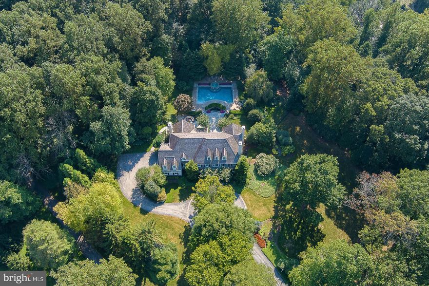 Welcome to 55 Green Lane, a rare opportunity to own an exquisite custom designed, Pohlig built Willistown estate situated on 4.3 breathtaking acres in the heart of Radnor Hunt Country. This hand-crafted masterpiece, offering spectacular views from every window and nestled in a secluded paradise, features sprawling grounds, mature landscaping and gardens, an expansive Bluestone patio and a heated Blue Haven pool, spa and waterfall plus a new exterior hardie-board siding renovation in 2023. An elegant circular driveway leads to the stone front residence featuring over 7,000 square feet of tastefully appointed living space on 3 levels plus an additional 1,500 square feet in the spacious finished walk out Lower Level showcasing a wet Bar, Game Room, Media Room, Exercise Room and full Bath   5 Bedrooms, 5 full Baths, 2 half baths, 3 fireplaces and 3-car garage. Main Level features extensive custom millwork and site-finished hardwood throughout, elegant front-to-back Foyer showcasing the magnificent views of the exterior grounds, beautiful fireside Formal Living Room with gas fireplace, elegant Dining Room with wainscoting and a large private Study with French doors, built-in cherry cabinetry, transom windows and a slate surround gas fireplace. The spacious Gourmet Kitchen features large Center Island, commercial stainless 6-burner gas range, pot filler, generous Butler's Pantry and adjacent Morning Room offering ample natural light and a tray ceiling. Family Room offers a stunning coffered ceiling, custom millwork and built ins, a third gas fireplace and atrium doors opening to the rear yard and patio. Completing the first floor are 2 half Baths, a large Mudroom with built-in custom lockers and dog washing station, plenty of closet space and exit to the 3-car garage. 2nd Level, accessed by the main or rear staircase, features a luxury Primary Bedroom Suite with Sitting Room, tray ceiling, plantation shutters, his & hers designer walk-in closets & a gorgeous Primary Bath with double-sided shower, separate vanity areas and a claw foot tub; 4 additional Bedrooms, 2 with en suite Baths and 2 sharing a Jack and Jill Bath; convenient 2nd Floor Laundry Room with white cabinetry and inset laundry sink. Large 3rd Floor includes fabulous Bonus Room space ideal as an additional Home Office, Media Room or Playroom. An added bonus to the Outdoor Living Area is the former barn, offering versatility for a conversion to a new pool house/cabana, additional living space or simply extra storage. This stunning on-of-a-kind property truly has it all combining, elegance, functionality and entertainment options.  A coveted and prestigious Radnor Hunt location and only minutes to Malvern Borough and downtown Wayne with the convenience of the train to Philadelphia and NYC, excellent restaurants, shopping and the area’s finest public and private schools.
