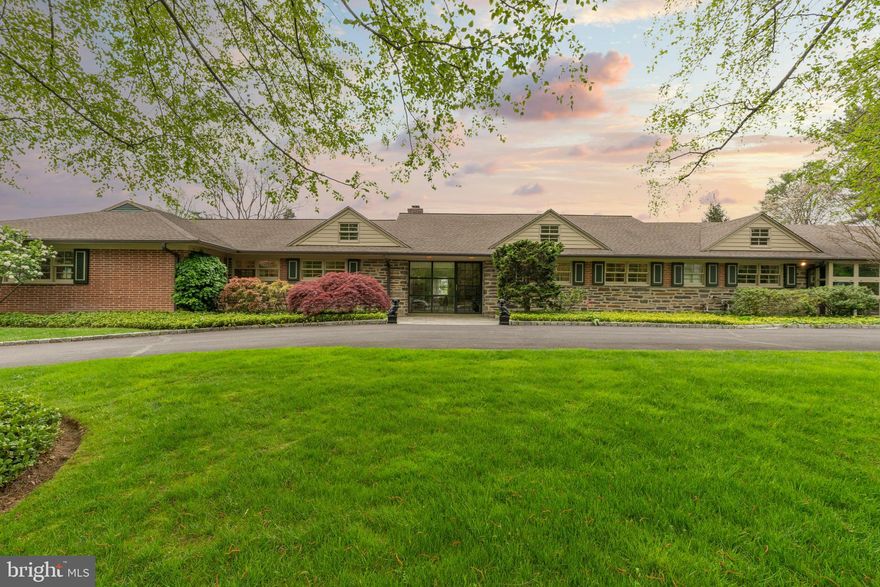 Set on over 3/4 acre filled with lush plantings, lovely perennial gardens and flowering trees, this 4-bedroom, 4.5 bath modern Ranch style home enjoys a quiet top-of-the-hill location, and simply exudes warmth and charm. The sweeping governor’s drive welcomes you into the bright foyer, and opens to the large living room, updated kitchen and hallway to the bedroom suites. The spacious and open living room with gas fireplace and built-ins has access to the rear covered patio, and pocket doors into the dining room. Walls of windows in both rooms overlook the impeccably landscaped rear yard. The eat-in kitchen with large island features custom cabinetry, Viking range, built-in Sub-Zero refrigerator, and a large mudroom/pantry with gorgeous honed soapstone counters, farmhouse sink and storage room. A sun-filled breezeway with slate floors and potting room offers access to the oversized garage. One of the bedroom suites with a new bath is also located in this wing of the house. Just off the foyer is a large study with walls of windows, a gas fireplace and built-in shelving. Two spacious bedroom suites, each with updated ensuite baths, can also be found in this section of the house. The owner’s suite features a brand-new bathroom with walk-in shower and radiant heated floors, ample closet space, and views of the lush yard. The partially covered rear slate patio overlooks the large fenced yard and will become a favorite place to relax and admire the incredible hydrangea, lilacs and cherry trees, or to watch the incredible variety of birds that pass through this area of town. This handsome home is just blocks from the heart of Chestnut Hill, two blocks from the train station, and boasts easy access to the Lavender Trail of Fairmount Park off of Crefeld St. Contact listing agents Jennifer Rinella and Michael Sivel for a private showing.