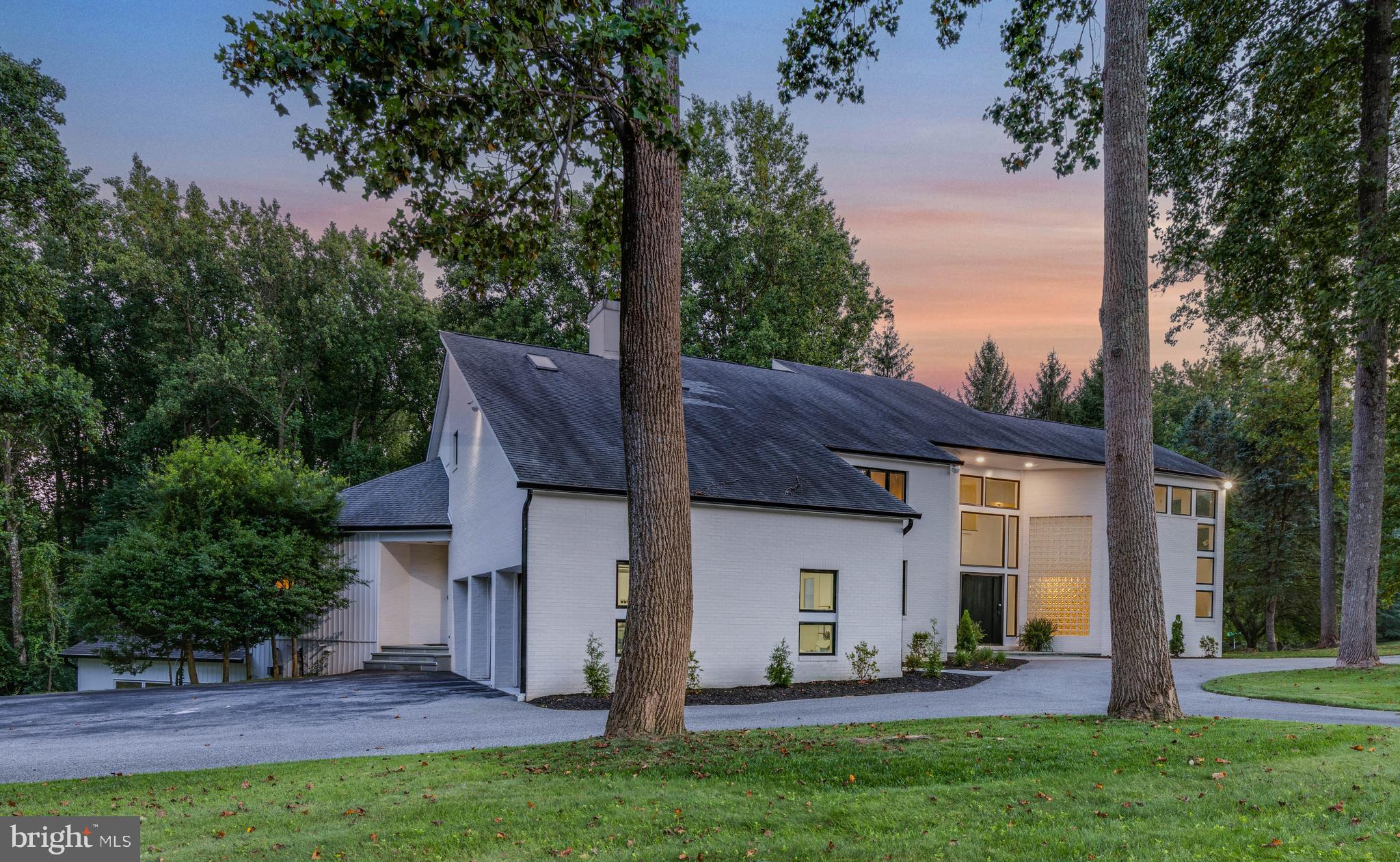 Live authentically. Unrivaled custom contemporary in the heart of Caves Valley. Architecturally stunning design with soaring ceilings, interesting angles and walls of glass throughout. Pull up and feel a sense of arrival as you open the 8 ft pivoting steel front door complete with facial recognition technology. Step inside to an open flexible floor plan with generous room sizes and a great flow. Sleek clean-lined interiors with a multitude of spaces to lounge and entertain. Expansive gourmet kitchen with oversized island, quartz countertops, separate Subzero refrigerator and freezer, Wolfe range and discreetly disguised walk-in pantry. Main level includes private guest suite and two additional bonus rooms, perfect for home office and playroom space. Step upstairs to find three spacious en-suite bedrooms, each with walk-in closet. Transcend through the double-doors into your luxurious primary suite, an oversized space filled with natural light, complete with private balcony overlooking greenery. Rejuvenate and relax in gorgeous spa-like bath which opens to one of the largest closets you have ever seen. Step down to lower level to an elevated entertaining space. Gorgeous porcelain floors lead you to indoor sports court wrapped in walls of glass, which opens to large personal gym. Around the corner you’ll find large recreation space with built-in bar and theater room. Tucked around the corner is an additional private guest bedroom with stunning bathroom. This contemporary masterpiece has recently been fully renovated. Move right in and enjoy. Nestled on a large 2.26 acre corner lot, the outdoor possibilities are endless. Cultivate your existence. The art of uniting human and home.