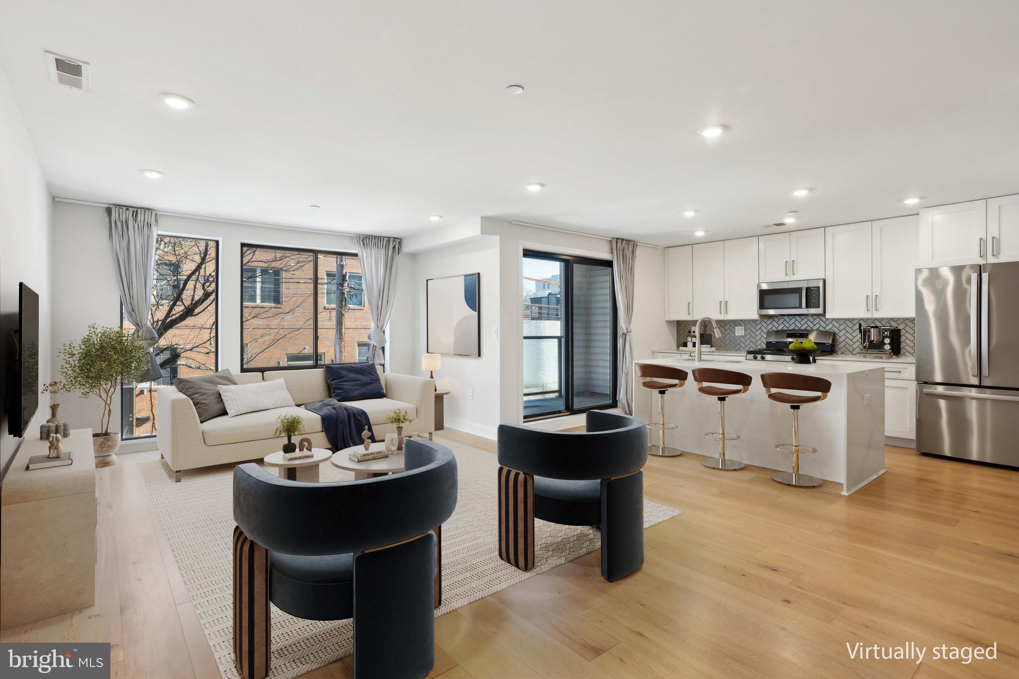 **NEW LOW PRICE! Don't miss out on this fantastic location close to sought-after Fishtown, shopping & restaurants, plus close proximity to Temple University's main campus! 6 years remain on the tax abatement!** Situated on the second floor of a well-maintained three-story building, this condominium unit offers the added privacy of its own dedicated hallway. This bright and airy condo offers an open layout with 2 bedrooms and 2.5 bathrooms, featuring stunning 7" white oak floors and walls of windows that fill the living and dining areas with natural light. The modern eat-in kitchen boasts sleek Quartz countertops, perfect for cooking and entertaining. Off of the kitchen, enjoy your private patio, perfect for sipping coffee or dining al fresco. Completing the open living area is a convenient half bath. The Primary Bedroom Suite features a walk-in closet and a spa-like ensuite full bathroom. The secondary bedroom is equally large with an adjacent full bathroom. Each bedroom features ample natural light through the walls of windows, and a stacked washer & dryer are conveniently tucked away between both bedrooms. This home offers both style and convenience in one of the city's most desirable areas!