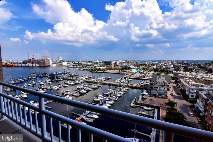 REDUCED TO SELL QUICKLY "as is". The property is in good condition. A MUST SEE WITH STUNNING VIEWS FROM THIS 12TH FLOOR 2  BEDROOM unit with two balconies! Large living-dining area with windows overlooking the harbor and access to the balcony. The kitchen is open to the living area and has white cabinets, an electric range, and a full-size stackable washer and dryer.  The entrance hall has a double coat closet and half bath.  Large bedroom with sliders to balcony, walk-in closet, and large bath with double sink, separate tub, and walk-in shower.  Double Doors to the second bedroom with a private balcony, with plenty of space for a desk and daybed for guests. Beautiful common area spaces, party room with pool table and bar.  An indoor pool and full gym. Full-time concierge and garage parking.  City living at its best.