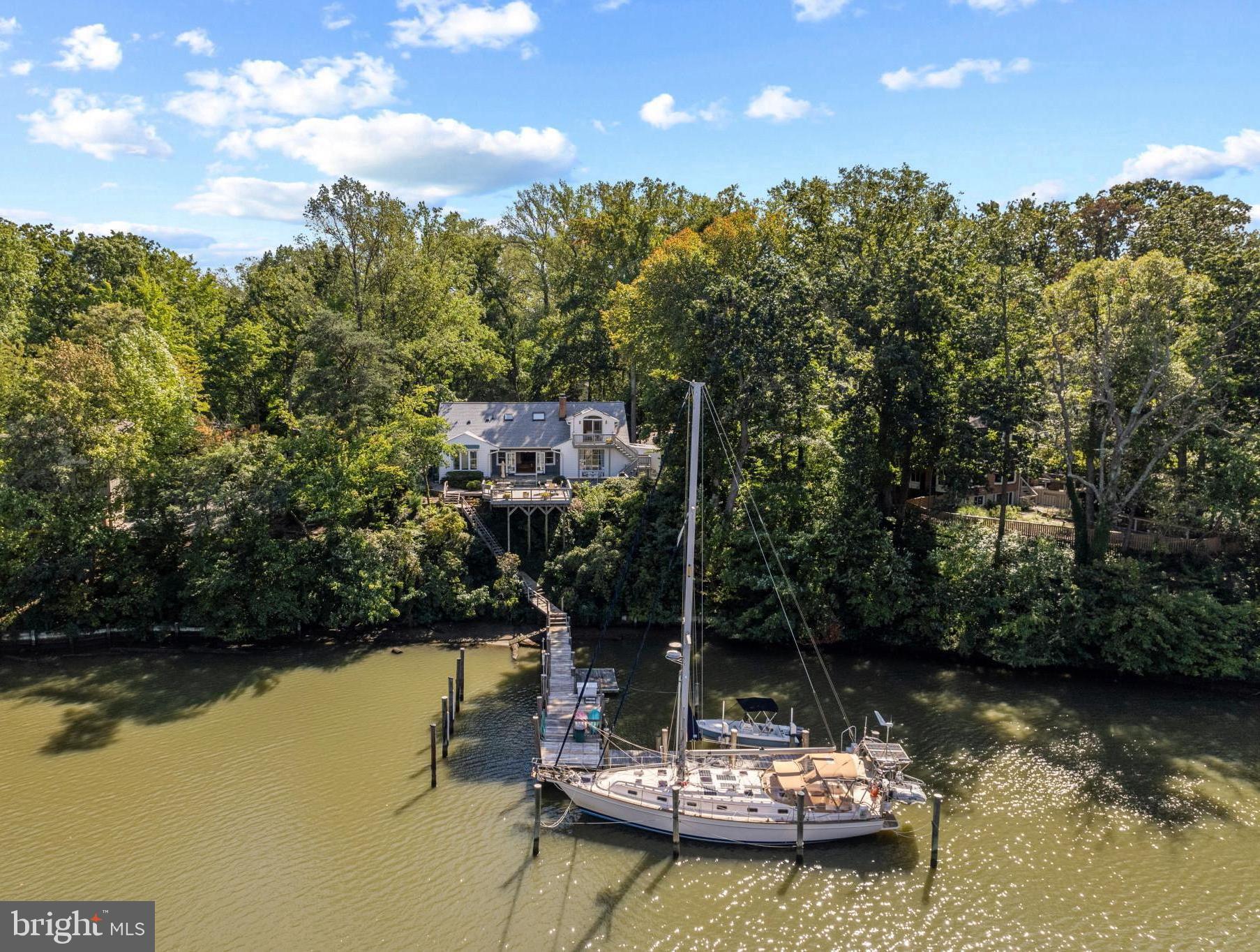Annapolis Waterfront Gem on Lake Ogleton – A Boater’s Deep-Water Paradise. 3104 Landfall Lane is a 5-Bedroom, 3-Bathroom, 3,100 square foot waterfront gem located in a cul-de-sac. The great room with stunning hardwood floors boasts double doors that open onto a large patio and deck overlooking the peaceful waters of Lake Ogleton. There are views of the lake from many rooms in the home where you can watch blue herons and osprey fishing alongside the intermittent kayaks and paddle boards. Boaters will appreciate the two deep water slips (6’ MLW) and 2,800 lb. lift as well as the sense of security vessels have tucked in the lake during storms. When it’s time to go boating, you’re on the Chesapeake Bay or the Severn River in mere minutes. Proximity to town makes a skiff ride to City Dock for an ice cream run a breeze! The home’s layout gives the owner many options. On one side of the main level, there is a waterfront room that could be used as a first-level primary suite with its walk-in closet and ensuite bathroom and there are two more bedrooms and a full bath. The dining room is next to the great room where the choices during your meal are enjoying the roaring fire and/or gazing at the water. The kitchen opens to the dining room making it convenient to serve your guests. A mid-level family room looking onto the cul-de-sac hosts a wet bar and could be used as a game room or TV room. Up a few more steps to the upper level is a completely renovated primary suite with sitting area, walk-in closet, and large bedroom with a balcony perched like a treehouse overlooking the lake … or just sit in bed with morning coffee and enjoy the view! The spa-like ensuite bath has gray marble-like ceramic tile, a double vanity, separate soaking tub and tiled shower. It truly is a getaway from the rest of the activities of the home. At the other end of the upper level is a renovated laundry room plus an additional area that can be used as an office or bedroom. A double garage with workbench provides protection from the elements and a place to tinker. 2023 new roof and many renovations since 2015.
Enjoy Anchorage’s amenities which include a marina, swimming pool, boat ramp, half basketball court, and rack for kayaks and paddleboards. Anchorage is a small community (106 homes) with no cut-through streets and mature landscaping and is located 3.5 miles from downtown historic Annapolis, one mile from the 340-acre Quiet Waters Park, 35 miles from Washington D.C. and 32 miles from Baltimore.
Do not miss the opportunity to purchase this gem located in one of the most sought-after Annapolis waterfront communities.