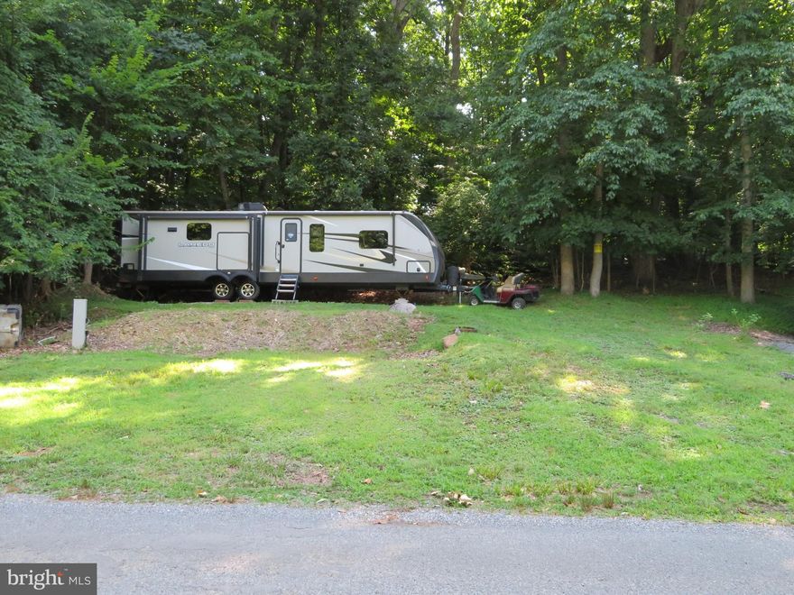 Vacant 3500+/- square foot lot with picnic table in Riverbend RV Park. Featuring a blank slate for you to make it your own. The lot backs up to woods for added privacy and is mostly cleared with an area ready for your RV. Minutes to the boat ramp with Potomac River access for boating, fishing & swimming. Yearly membership includes water, pump out, electric, trash and the park amenities such as pools, putt putt, basketball court, tennis court, holiday fireworks for July 4th, car show, carnival, restaurant, playground, ball field and much more.  Riverbend RV Park is located close to shopping, I81 & The C&O Canal for hiking & biking. Own this getaway in as little as 3 weeks. Call today before it's gone! **Gated community-pass required for entry. **Riverbend sales are SOLD "AS IS", CASH only and seasonal.** (Direct TV and Frontier Internet available with service install/hookup).