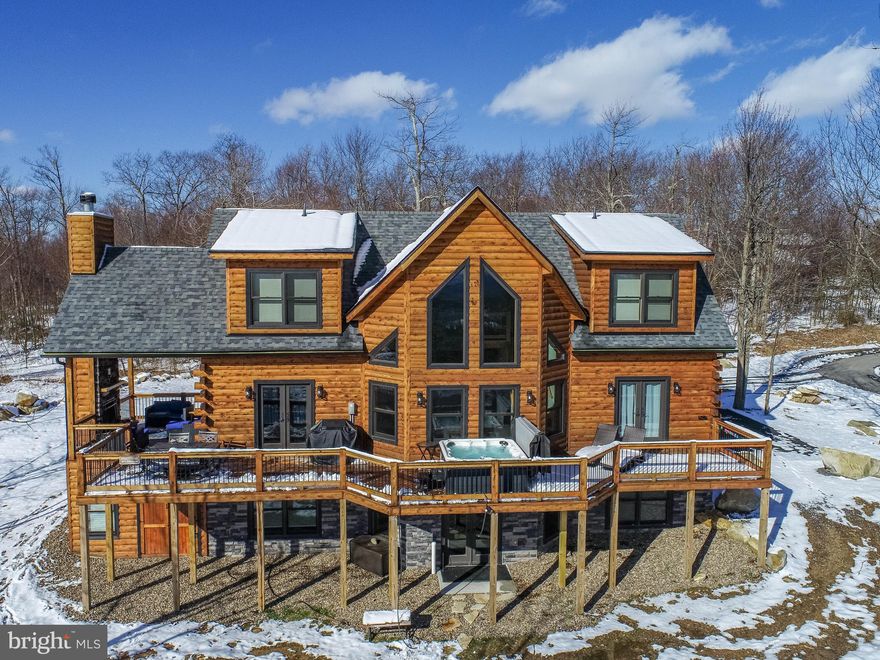 "Sunshine Chalet" brings the very best of mountain resort living at Deep Creek Lake, MD to you and your family.  One of the best scenic vista views in North Camp and situated so as to always have this view. This fully furnished modern yet rustic log home features 3 large ensuite bedrooms on the main and upper floors as well as two additional bedrooms on the lower floor with a total of 4 1/2 baths. The quality and custom design is immediately apparent as you enter to find an enormous granite kitchen island for all of your entertaining needs with the goal creating a large and inviting place to gather. The double-sided stacked stone fireplace extends all the way from floor to the ceiling of the upper level creating a third cozy gathering place. There is an additional wood fireplace in the gorgeous covered porch area perfectly situated to enjoy the gorgeous scenic vistas from the comfort of  lounge chairs and couches. This "turn key" home is a highly successful vacation rental and is full equipped with everything needed to entertain including pool table, flat screen tv's in every room, private and protected storage area long enough for kayaks and wide enough atv/snowmobile, and the list goes on. Conveniently located to Chair #7 of the Wisp Ski Resort, The Adventure Sports Whitewater Course, numerous trails and parks for hiking and biking, shopping and, of course, Deep Creek Lake, this property is an ideal mountaintop retreat.