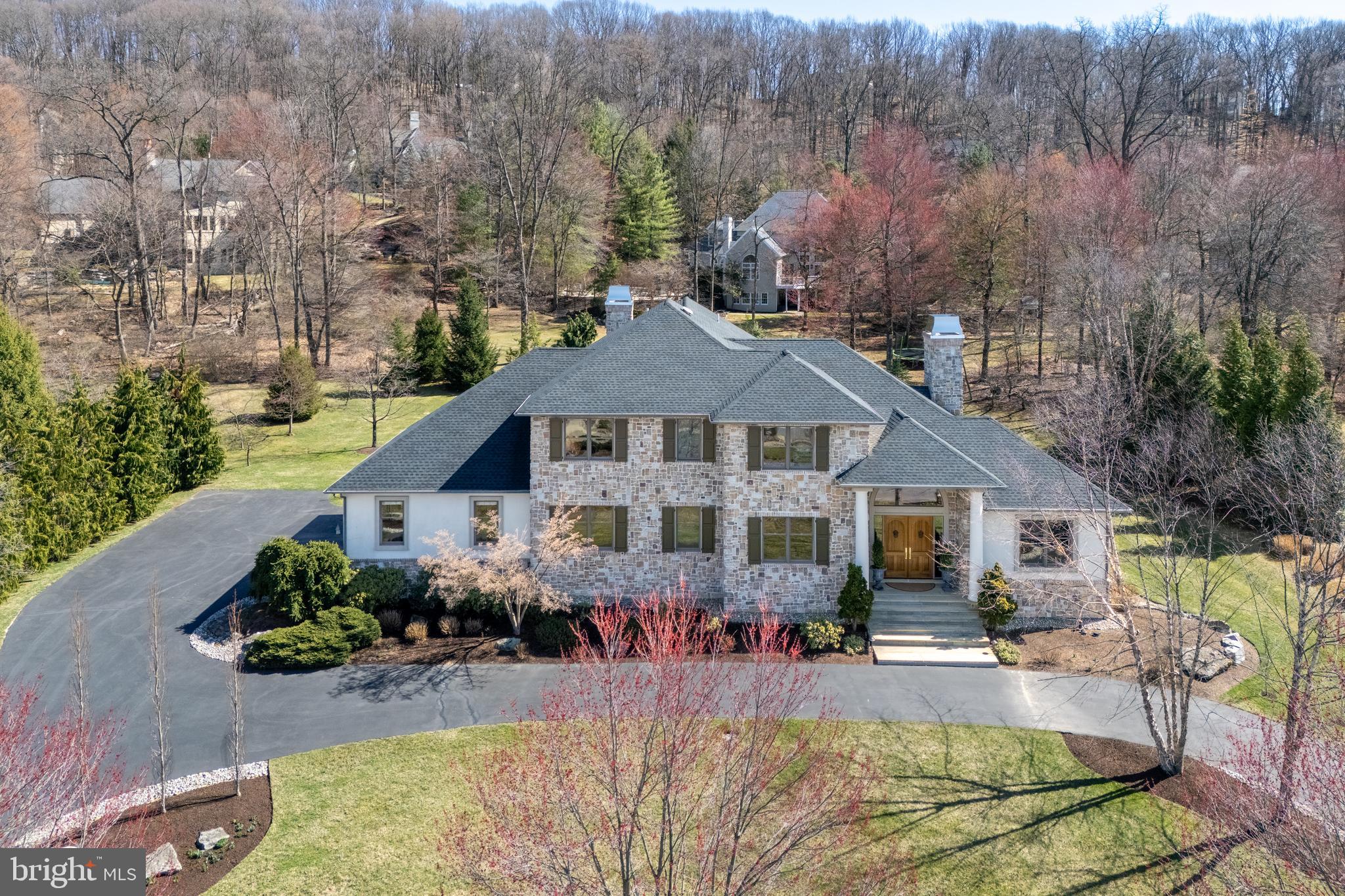 Nestled in the highly coveted Weyhill Woods neighborhood, this exquisite 4-bed, 6-bath home seamlessly blends everyday comfort with exceptional design. Soaring ceilings, custom millwork, and a dramatic staircase set a sophisticated tone. At its heart, the gourmet kitchen boasts luxe appliances, a butler’s pantry, bespoke cabinetry, and a stunning 3-inch marble island. The space flows effortlessly into a charming breakfast nook, cozy keeping room, and an enclosed den, both warmed by their own gas fireplaces—perfect for intimate gatherings. A built-in wet bar enhances the home’s effortless elegance, seamlessly connecting the main living areas for refined entertaining. A private, first floor guest ensuite is ideal for visitors or multi-generational living, while two dedicated home offices offer elegant workspaces. Upstairs, the primary suite is pure indulgence with two spa-inspired bathrooms and custom walk-in closets. Two additional ensuite bedrooms complete the upper level. The finished lower level extends the home’s versatility, offering a rec room, fitness area, dedicated workshop, and abundant storage. Outdoors, the professionally landscaped grounds impress with a backyard patio, soaring covered front porch, and circular driveway leading to an attached three-car garage—all enhancing the home’s striking curb appeal. Perfectly positioned near top-rated schools and the picturesque Saucon Rail Trail, this residence offers an unparalleled lifestyle of luxury and convenience.