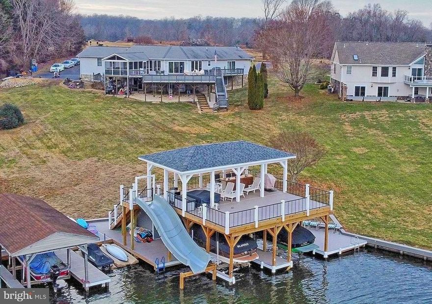 You have to see this gorgeous home on the public side of Lake Anna!!! Located in one of the most desired waterfront communities on the lake, Tara Woods. The owners live in this home full-time, but have used their home as a short-term rental, periodically, making this a fantastic investment property (reviews in photos and documents). The former boat house with replaced in 2022 with a fabulous new one, valued at $220k! The boat house is two stories, 1800 SF, two covered boat lifts, and a storage area for all your water toys/vests. The 2nd story boasts a TV, fridge, open and covered lounging areas, plenty of space for entertaining, amazing views, and yes... a WATER SLIDE. Inside the home, the owners have made another $100k+ in upgrades since 2019, including brand new flooring throughout the entire home. The foyer was re-engineered to vault the ceilings. The owners added shiplap to the ceilings to add texture and character to the main living area. When you walk in the front door, you are greeted by a beautiful view of Lake Anna. The living room, dining room, kitchen, and primary bedroom all have beautiful views of the lake. There is a massive back deck for entertaining, which overlooks the lake. The deck has a covered screened porch to shield you from the hot summer sun and weather. The lake-level has an additional living room, office, three bedrooms (not to code due to no window egress), and two full bathrooms. HIGH. SPEED. FIBER. INTERNET. Enough said. The home is in a great location by land and by water. By land, you are only 10 minutes from the hub of Lake Anna's restaurants, breweries, cidery, and more! By water, you're on the deeper south end of the lake, near Pleasants Landing and the brand new El Gran Patron Mexican restaurant. This is a fantastic, move-in-ready home. All that's needed is a new family to call this beautiful property their own!
