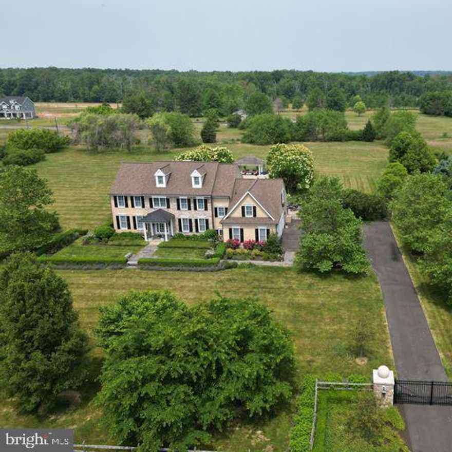 Sophisticated country living combined with city elegance.... Sladek Manor provides the best of both worlds.  This custom home sits on 5+ acres that are gated and fenced with approximately 4,500 SF of elegant and yet warm living space. 9 FT ceilings and hardwood flooring run throughout first floor of the home, with custom interior doors, crown moldings and coffered ceilings. The 2-story foyer with its marble floor and beautiful chandelier presents a gracious space in which to greet your guests. The formal Living room is to the left and the very spacious Dining room with coffered ceiling to the right. Straight ahead is the Kitchen which is an entertainer's dream flowing easily from one room to the next. You will love the Kitchen with its coffered ceiling and expansive granite island (that holds a wine/drink fridge and an ice maker) an eat-in Dining area with access to the 2nd stairway, top-line appliances including a Wolf range and built-in Sub-Zero refrigerator. The floor-to-ceiling glass doors have remote blinds and frame the amazingly beautiful view of the lush landscaping, pool and pool pavilion. The Family room opens to the Kitchen and has a lovely coffered ceiling and a wood-burning fireplace with surrounding paned windows.  The Study/Office opens off the Family room and would be a wonderful place to work from home. The hallway off the Kitchen leads to the huge walk-in Pantry, updated Powder room and Laundry room with built-in storage cabinets, a dog washing station and access to the Garage.  Upstairs are 4 Bedrooms and 3 full Baths.  The landing has an inviting window seat and built-in shelving with storage. Entering the Primary Bedroom suite you will find a coffered ceiling and an adjoining Sitting room, a very spacious walk-in closet and a beautiful primary bath with large shower, soaking tub, double sink vanity and private toilet closet.  Bedrooms two and three share an updated hall bath. Bedroom four is also en suite and includes a 2nd room perfect for Office or Gym.  The attic was built with the possibility of finishing and has an easy-access turned stairway with landing.  The back staircase leads to the 1st floor landing that includes direct access to the eat-in Kitchen, the Garage. as well as the stairs leading to the Basement.  The unfinished Basement has 9’ ceilings and the potential to add a bathroom. The side-entry 3 car Garage has an epoxy floor. A new roof was installed in 2020 and includes copper gutters. The furnace and A/C have both been replaced along with the hot water heater, water purification system and water softener system. There is a full-house backup generator.  A Sonos music system plays throughout the 1st floor of the house, the front courtyard, the Garage, the pool/patio area and the pavilion. LED lighting has been upgraded throughout the house. Poolside gardens and Front gardens are irrigated.  All of this and a location that puts you minutes away from the quaint and historic towns of New Hope, Lumberville, Carversville and Doylestown with their fabulous restaurants, shopping and entertainment venues. Easy commute to New York, New Jersey or Philadelphia. This home is located in the award-winning Central Bucks School District and is close to everything while remaining quietly tucked away to provide the peace you value.