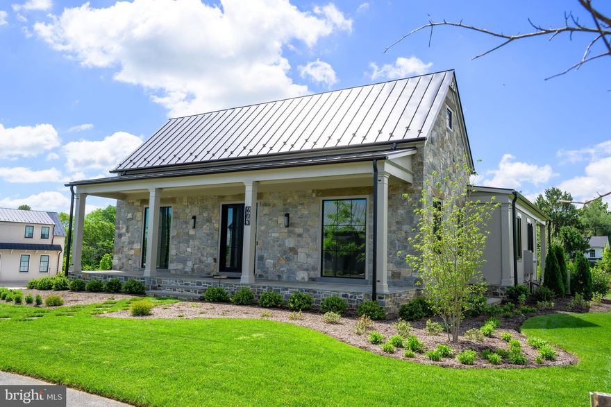 Purchases added a garage with pool bath to their purchase. This stunning stone exterior Hunt Box is ready for you. Recently completed and ready for you to discover what's next. Opportunity to live adjacent to Forbes Five-Star Salamander Resort & Spa in historic town of Middleburg, in Virginia's spectacular Wine and Hunt County.  Historically designed for the equestrian and fox hunting lifestyle, English Hunt Box architecture serves as the inspiration for this exceptional home plan. With its classically inspired character and understated elegance, owners enjoy modern-day versatility in a home rich with charm.  At 3,663 square feet of refined  living space, this 4 Bedroom plus Media Room / 4 full and 1 half Bath residence boasts elegant features and finishes, including European Oak flooring, Quartzite countertops, designer tile, and expansive windows and doors. The home boasts expansive front and rear random bluestone porches for living, an outdoor kitchen for al fresco dining and relaxing. The focal points upon entry are the 55-inch fireplace and stunning kitchen (with upgraded flush inset cabinetry doors).  This spec home boasts many upgrades, and certainly the home's mudroom is an example - providing space for prepping and projects. Light floods the space from all angles, including the ample and generous windows in the vaulted ceiling. The main living spaces open to an expansive rear covered porch, measuring 53 feet by 14 feet. The lower living space features two additional bedrooms with ensuite bathrooms and walk-in closets, recreation/media room with wet bar, and a flex/home fitness space featuring barn doors. There is even an excellent use of space under the stairs - glassed in wine storage with focal lighting - a buyer could still convert to a conditioned wine space. Residences at Salamander bring together collaborative partners with spectacular results ensuring an incredible lifestyle and experiences for those making the community their home.  Whether a permanent residence or restful retreat, end each day beholding Blue Ridge beauty from your pastoral paradise. All this and just short blocks to Washington Street and all the terrific shopping and dining options of charming Middleburg. Truly Town, Country and Resort living all in one.