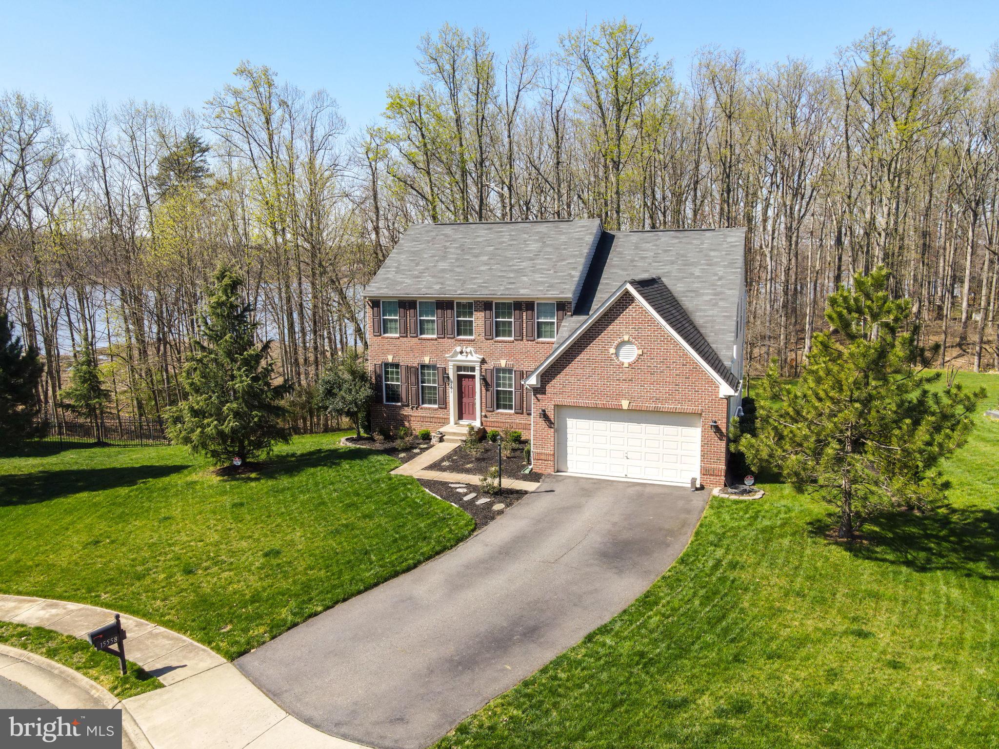 This exquisite Colonial Retreat is nestled on 2 Acres in a Secluded Cul-de-Sac with Serene Water Views and Direct Access to Neabsco Creek. Indulge in the allure of this stunning colonial residence situated on a sprawling 2-acre lot that culminates at the shores of Neabsco Creek. The property extends into the creek, affording you the remarkable opportunity to savor 150 feet of captivating waterfront. Revel in the vista of the creek from every level of this elegant three-story home, creating an immersive connection with the natural beauty that surrounds you. Envision yourself ensconced on the property, a sublime vantage point from which to relish the sun-dappled waters and marvel at the uninterrupted spectacle of the setting sun. Descend through a meandering pathway enveloped by verdant woods and a park-like ambiance, leading you to a private dock where the rippling waters bestow an undeniable sense of calmness and ease. With over 4100 square feet of meticulously designed living space, this residence exudes an unmistakable sense of luxury. Luxury vinyl plank flooring graces the main and upper levels, and carpeting on the lower basement level. The expansive and renovated kitchen stands as a testament to culinary excellence, boasting state-of-the-art appliances and an oversized island that seamlessly accommodates food preparation and gatherings. Abundant cabinetry ensures ample storage, while the adjacent morning room presents a charming space for casual dining or relaxation. A grand deck adjacent to the kitchen offers a splendid venue for hosting gatherings and soaking in the year-round enchanting wooded waterfront panorama. The family room is adorned with a custom hearth and a gas fireplace, providing a cozy haven for relaxation. The main level's formal living room, bathed in natural light, is ideally versatile to serve as a home office. The sizable formal dining room provides an elegant setting for hosting sophisticated dinners. Ascend to the upper level, where a generously proportioned primary bedroom awaits, complete with two oversized walk-in closets and an exquisite ensuite bathroom boasting a standalone shower and a soaking tub. Begin your day with a tranquil water and tree-lined view that inspires serenity.Plenty of extra storage space are ready to accommodate your needs, whether you envision an invigorating home gym or other inspired uses. Step out to a picturesque patio area, providing a comfortable retreat for outdoor seating and relaxation, while the pathway leads you to the water's edge. The boardwalk and deck are as-is, and use at your own risk. Beyond the property, you'll find the Neabsco Boardwalk less than 2 miles away, an enticing location for leisurely strolls. With the convenience of the VRE within walking distance, commuting is effortless. A brief 6-minute drive leads to the Stonebridge Potomac Town Center, a vibrant hub featuring Wegmans, Starbucks, The Apple Store, Alamo movie theater, an array of restaurants, shops, and more. Coupled with the proximity to Highway 95 and the HOV entrance, your daily commute to Washington D.C., Ft. Belvoir, Quantico, and The Pentagon is seamlessly efficient, establishing this residence as a gateway to both leisure and convenience.