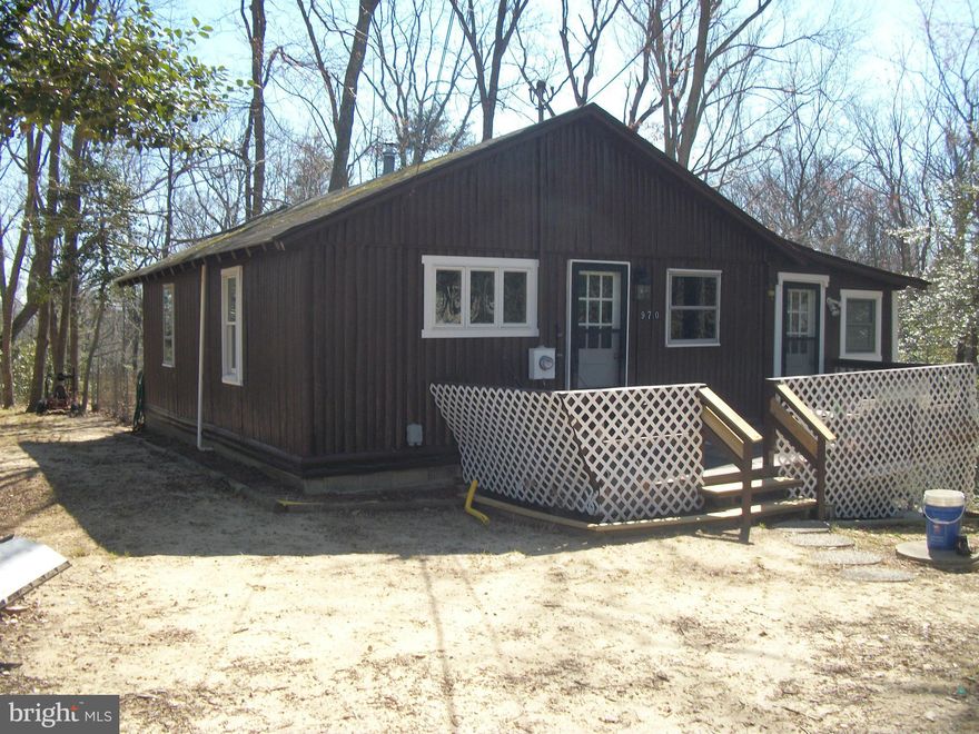 Cozy 2 BR, 1 Bath Cabin on 2 Lots, surrounded by wood line at the end of a cul-de-sac. Front & Back Decks.  Very nice inside. NEW windows, roof, and septic. Walls insulated and a wood stove.This home looks great.  You can see the Chesapeake Bay from the Lot. If you are looking for a summer home or to stay year round, this is it. Open Kitchen, all wood floors.  What a great  buy & investment.