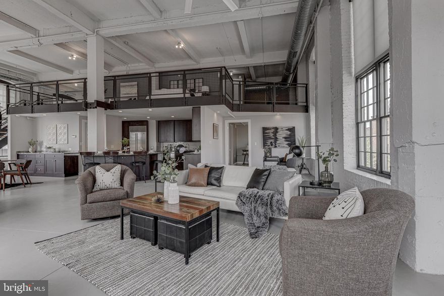 ***Tour this condo virtually via the linked 3D Matterport Tour!*** It's a beautiful day as you and your friend stroll home from shopping in Harbor East. During the short two block walk, you leave the hustle and bustle of Baltimore's favorite shopping district and enter the charming, established neighborhood of Little Italy. You wave to some neighbors as you pass and then, as you enter your industrial loft building, you are transported to an unexpected oasis. Your friend, as she takes in the trees and foliage of the shared courtyard, says the same thing every visitor does, "Wow! I never would have guessed this was here!" You take the elevator to the third floor and enter your loft: a dramatic, one of a kind space. It never gets old coming home to this character filled abode! The double-height ceiling, the tall windows on three sides, the century-old brick, the artful blend of wood, metal, and concrete -- this space hits all the right notes. You debate whether to go out to dinner at one of Little Italy's fun eateries, but you decide to cook in tonight, and what a pleasure it is to prepare dinner in this big, beautiful kitchen! You extract a bottle of wine from your Sub Zero wine refrigerator and begin to create some culinary delights at your 6-burner Wolf range. After enjoying dinner at the huge island, you notice that some neighbors have congregated in the courtyard around the fire pit, so you and your guest go downstairs to join them. When the merriment wraps up, your guest retires to the private, main level guest bedroom suite and you head upstairs to the owner's mezzanine. You enjoy a soak in the 6-foot Duravit bathtub, thinking about how lucky you are to live in a place that offers this blend of downtown convenience and small town camaraderie. What a unique and wonderful place!