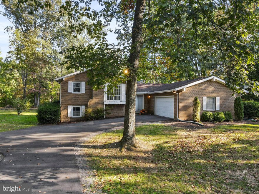 Lovely, park-like setting surrounds this well maintained home.  Split (tri-level) design has 2 car garage, shed, upper level with 3 bedrooms and 2 full baths, main level is kitchen, foyer, living room, lower level is another bedroom and family room with wood burning fireplace.  Plenty of storage, beautiful parque wood floors, porch.  Home has so much to offer in North Berkeley County off Williamsport Pike. Woodbrier Manor adjoins Woodbrier Golf Course, a public 9-hole course.