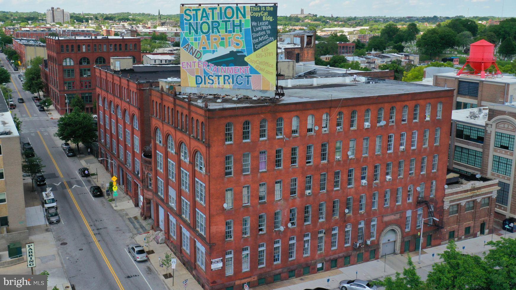 Online Auction Only! Bidding begins Friday, September 5th and ends Wednesday, September 10th, 2025 at 1:00 PM EST. (12pm for 419 E. Oliver MLS#____) List price is opening bid. Copycat Building is a rare landmark redevelopment opportunity located in Baltimore’s thriving Station North Arts and Entertainment District. This massive 265,000-square-foot, 6-level building encompasses a full city block and is a prominent feature of the Baltimore skyline. With its rich history and prime location, the Copycat Building is an ideal investment for a visionary developer.
Originally built in 1897 as the main factory for the Crown Cork & Seal Company, the building is a marvel of Victorian Industrial architecture. For decades, it was a hub of innovation, producing the world-famous crown-style bottle caps. In the 1980s, the building transformed into an iconic live-work space, becoming a haven for Baltimore's burgeoning art scene and fostering a vibrant community of creative professionals. This unique heritage makes the Copycat Building more than just a property; it's a piece of Baltimore history.
Property Features
This mixed-use property is zoned IMU-1 (Industrial Mixed-Use) with a Planned Urban Development (PUD) designation, allowing for a wide range of uses, including multifamily, retail, office, and industrial. The 1.25-acre site offers significant development potential.
Key Features include:
• Size and Structure: 265,000+ square feet on six levels, constructed with a durable concrete, steel, and masonry frame.
• Parking: A private parking lot, indoor garages, and abundant street parking.
• Accessibility: Multiple passenger and freight elevators, loading docks, and bays.
• Utilities: 3-phase electric service and a full wet and dry sprinkler system.
• Signage: A massive 3,000+ square-foot rooftop billboard with high visibility from I-83 and Penn Station.
Unbeatable Location
The Copycat Building is strategically located in the heart of the Greenmount West Planned Urban Development and the Station North Arts & Entertainment District. Its location offers unparalleled access and visibility.
Location Highlights:
• Adjacent to Penn Station: With 3 million commuters passing through annually, the building is perfectly positioned to attract residents and businesses seeking an easy commute. The ongoing $150 million renovation of Penn Station will further enhance the area with new residences and retail.
• High Visibility: The building is a landmark visible from I-83, which sees over 110,000 cars per day, and from Penn Station.
• Walker's Paradise: A Walk Score of over 90% means residents and tenants can easily access major employment centers, educational institutions, entertainment venues, and shopping.
• Development Incentives: The property is located in an Opportunity Zone and qualifies for Historic and Energy Incentives, providing significant financial benefits for redevelopment.
• Connectivity: Quick access to major highways (I-83) and key Baltimore neighborhoods like Downtown, Mt. Vernon, and Charles Village. The building also offers expansive views of the Baltimore skyline and visibility to the Inner Harbor.
The Copycat Building represents a unique opportunity to transform a historic industrial icon into a modern mixed-use development, capitalizing on Baltimore's ongoing renaissance and the growing demand for housing and commercial space.