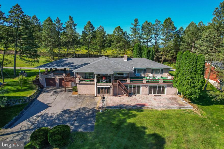 Must see to believe! This incredibly unique 20+ acre estate in the
northern Lehigh Valley was originally built as an executive retreat,
and is comprised of two homes, garages, and even two small
cabins- making it perfect for a family home or even a Bed & Breakfast.
Secluded privacy, and yet 15 minutes to Allentown and major
highways. Perched at the top of a gently sloping tree-lined hill,
homes overlook the expansive front lawn, with a stunning view!
Ideal for entertaining with multiple patios, a wet bar and
recreation areas, including an indoor built-in hot tub and sauna,
the 6,000+SF main home has 6 BRs, each with en suite full baths,
and two full baths on lower level sauna/hot tub area, half bath on main level, two kitchens- one on each level, dining room, multiple family rooms, 2 fireplaces, and attached large 2 bay
garage. 704 SF Guest house has 2 BRs, 1 Bath, kitchen and LR, 1
car garage. Detached 2 story 3,700 SF garage with 6 bays &
workshops, and a 1,200 SF RV garage with oversized door. Lower level Rec Room has indoor inground pool which has flooring installed over. Possible to reopen to enjoy year round swimming!
Well built and impeccably maintained, this home is waiting to be made
into your dream home. Act 319 for taxes.