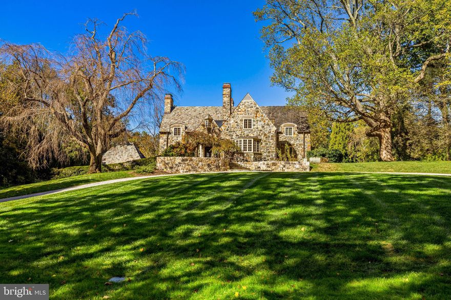 Turn into the paver block estate drive and be instantly transported to the Cotswolds! A storybook stone home majestically sited on 3.5 professionally landscaped and maintained acres. A barrel-vaulted front porch on a bluestone terrace leads to the foyer with a beautiful cased archway to the stair hall with its elegant staircase with French doors on the mid-landing. Two matching cased archways lead from the foyer to the living room and library. Sumptuous and also cozy, the paneled library, warmed by a fireplace,  is fitted out with custom built-in bookcases. The elegant living room features a bay window with built-in window seat and an additional window in an arched and paneled alcove lined with built-in bookcases, a perfect reading nook. A formal dining room with French doors to a patio is just off the living room. An amazing custom gourmet kitchen with fireplace, granite counters, stainless steel appliances and Wolf commercial grade gas range flows effortlessly to the family room with fireplace, breakfast area and window wall with French doors to the patio. Two powder rooms and a mudroom complete the main level. A luxurious primary suite awaits on the upper level with a fireplace, an updated spa bath with heated floor, sitting room/office and 2 large custom fitted dressing rooms. 2 additional large bedrooms, each with a private bath complete this level. An amazing walk-out lower level includes a media room with access to the  sauna and full bath, 2 bedrooms each with private bath and the laundry room. Exceptional outdoor venues for entertaining or just relaxing that include a bluestone patio off the family room and kitchen, partially covered with a pergola, and an additional patio with French doors from the living room and dining room. A 3-car detached garage, built to match the house, includes an upper level guest/au-pair suite or the perfect getaway as an office or studio.