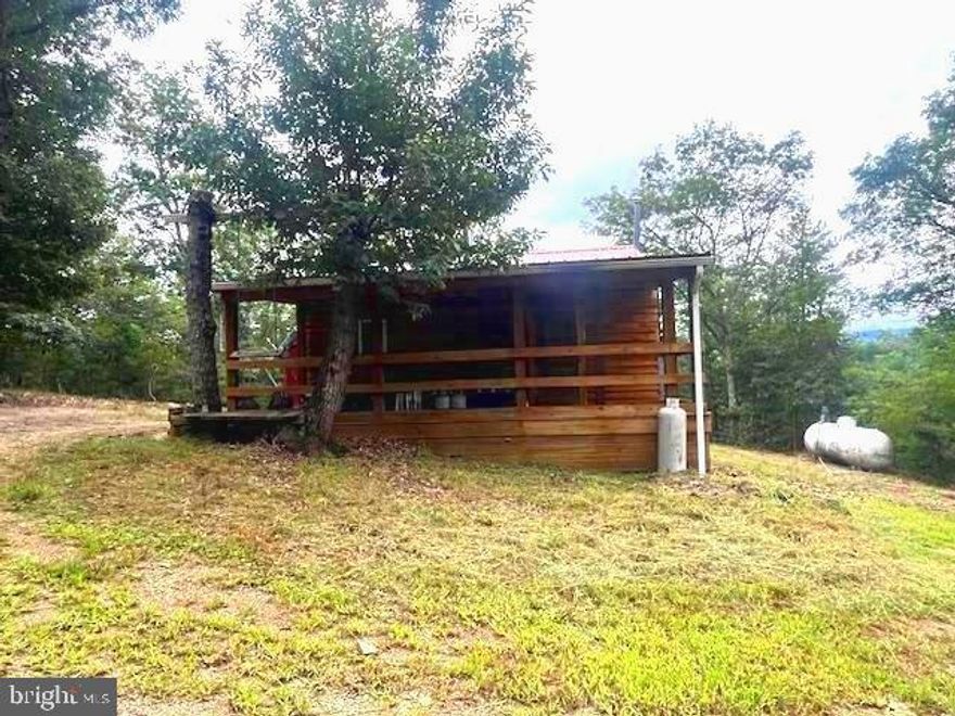 LOOKING FOR ENDLESS MOUNTAIN VIEWS ALONG THE PRIVATE  COME TO THE MOUNTAINS OF WV  ON 20+  UNRESTRICTED WITH ENDLESS VIEWS! NO HOA! TOTAL PRIVACY!!  "OFF THE GRID."
  
Escape to the tranquility of the mountains with this quaint, remote cabin retreat, with a new metal roof in 2022.  The private lot is on unrestricted with  20.26 acres of wooded. There's  plenty of  level  space around the cabin, then slopes downward   leading to the end of a quiet "off the beaten path". It's perfect for nature lovers, hunters, or anyone seeking peace and solitude. All types of wildlife roam all over the 20.26 acres, with  No Restrictions.  Plenty of mature timber to harvest, if desired, or plain for an addition to the small cabin. Enjoy breathtaking mountain views and the freedom to explore, relax, or unwind however you choose. This off-grid cabin is equipped with a wood-burning stove and a supplemental propane heating source, ensuring warmth and comfort on cold winter nights. While there is no traditional electrical power, there are generators to run the Refrigerator.  There's plenty of wood to harvest for the cast iron wood stove. There's no installed well.   There is a septic system & solar panels provide energy for a truly self-sufficient lifestyle—ideal for those looking to disconnect and embrace rustic living.  The Kitchen has a gas-burning stove and oven, along with a Refrigerator.  The combined  Living and Dining area, with a sectional couch and a Flat Screen TV and warmed by a wood-burning stove.   There are several storage  buildings, along with storage under the cabin.  There's  1 Bedroom / 1 Full Bath. The cabin is located at the end of the road and very private and  a decent dirt / gravel road to the Cabin.  Drill a new well and skip the water service, If preferable.
The newer metal roof was installed in 2022!!  Whether you're looking for a weekend getaway or a secluded hideaway, this property is your gateway to the best of West Virginia’s natural beauty. Don’t miss the opportunity to make it  your own   The only sounds are the winds blowing, wildlife, birds and deer running all over the property.  It's located just outside on the quaint  area of Burlington, just off of Rt. 50!