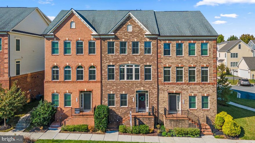 This brick-front townhome in the Villages of Urbana blends elegance, comfort, and convenience across four finished levels—including a coveted loft with rooftop terrace, and a peaceful pond view.

The main level is open and bright, featuring hand-scraped engineered hardwood floors, Hunter Douglas custom window treatments, and abundant natural light. At the center is a gourmet kitchen with an expansive granite island, stainless steel appliances, and cabinetry that offers generous storage. The morning room bump out provides extra space for dining or entertaining, creating a layout that’s both stylish and practical.

Upstairs, the owner’s suite includes dual walk-in closets and a spa-like primary bathroom with a custom-tiled shower. Two additional bedrooms, a full hallway bath, and an upper-level laundry add everyday ease. The top floor offers a private suite—perfect as a fourth bedroom or flex space—with its own full bath and a rooftop terrace ideal for summer evenings or watching fireworks on the Fourth of July.

The lower level offers even more versatility with room for a media lounge, office, studio, or gym, plus rough-in for an additional full bath, storage, and access to the two-car garage.

Life in the Villages of Urbana means access to award-winning schools, three resort-style pools (one with a lazy river), a clubhouse and fitness center, miles of walking trails, and walkable access to shops, dining, Starbucks, the library, and Urbana Town Center. With style inside and unmatched amenities outside, this home is the perfect blend of sophistication and convenience.