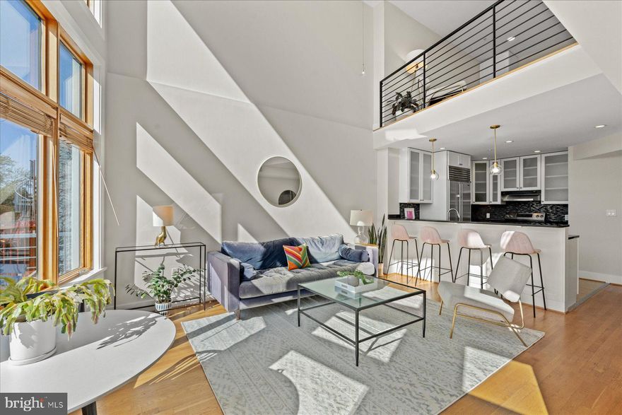 PRICE CORRECTION!!  Penthouse perfection in Logan Circle! This bright and airy 2-story, 2-bedroom condo offers stylish city living in one of DC’s most sought-after neighborhoods. Soaring floor-to-ceiling windows span the back wall, flooding the space with natural light and showcasing sweeping views—including the National Cathedral. The main level features an open layout with a private balcony, ideal for both relaxing and entertaining. The spacious first floor primary bedroom serves as a true retreat, and a larger sized bathroom boasts dual sinks and an oversized bathtub. Upstairs, you'll find a large second bedroom and a private roof deck offering a quiet outdoor escape. With generous indoor and outdoor living spaces, this home is perfect for hosting or unwinding in style. One separately deeded parking space conveys, along with low condo fees. All just steps to beloved neighborhood spots like Nina May and The Little Gay Pub—welcome to the best of Logan Circle living.