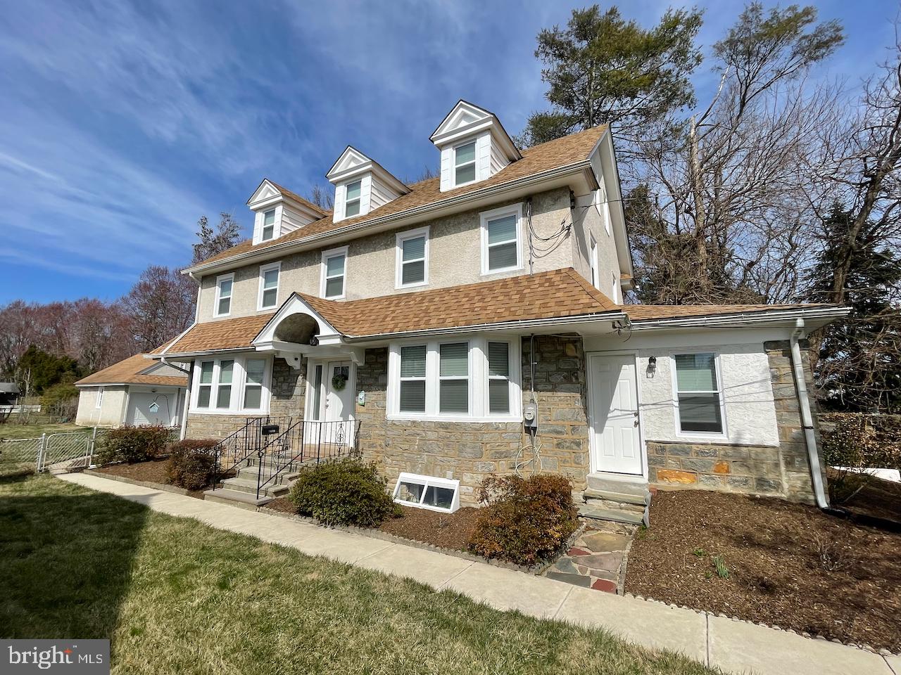 Welcome to this beautifully renovated center hall colonial home! From top to bottom, this elegant home impresses with bright, sun-filled spaces, all the amenities you could imagine and great sized rooms renovated in 2022. Walking up to the home you'll notice the larger sized lot (60' x 150'), along with the private driveway on the right side of the home that leads to a 2 car detached garage. A pathway from the street leads you to the main entrance at the left side, where you'll step up and into a welcoming and generously sized center entrance hall that includes a half bath. To your left, an incredible space that includes a open dining room with bay window, as well as, open modern kitchen (2022) with center island, loads of white cabinetry, pantry closet, granite countertops, tile backsplash, and stainless steel appliances. Further a back exterior door leads to the driveway, the large level rear yard and garage. Back inside, to the right of the center hall, you'll find a formal living room with stone fireplace and then step down to an enclosed/finished front porch with exposed stone wall. Heading to the 2nd floor, you'll find 2 bedrooms, a renovated hall bath with tub and tile surround, as well as, a primary suite with full bath (beautiful stall shower with seamless glass) and walk-in closet. The open staircase continues to a full 3rd floor where you'll find 2 more bedrooms and another renovated hall bath with shower! Back to the kitchen, a set of stairs lead down to the finished lower level that extents the full length of the foundation with vinyl plank flooring and recessed lighting. You'll also find a large laundry room with plenty of room for storage. Other incredible features include 2 HVAC Systems providing 2 zone heating and air, refinished hardwoods throughout, 200 amp electric, insulated replacement windows, custom blinds and more! Located in a stunning treelined neighborhood and just minutes from public transit to Philadelphia, schools (public and private), restaurants and local shopping. Its rare to find a home so nicely complete...don't miss this opportunity to own!