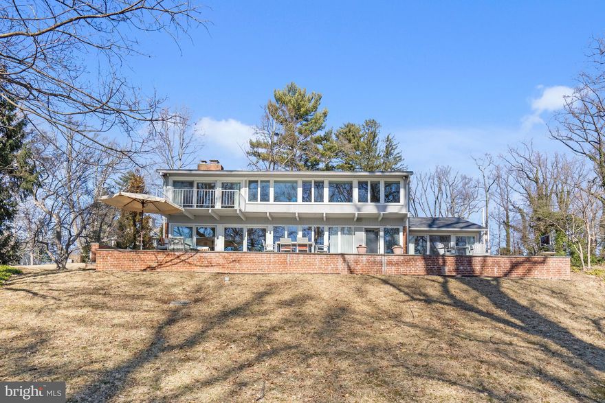 A remarkable find overlooking Lake Roland. This property is a treasure. One of the finest streets in Baltimore County with the feel of the countryside and the convenience of the suburbs. This custom mid-century modern home has been meticulously maintained and improved. A full wall of windows/patio sliding doors in the Living/Dining Room provide your first glimpse of the sparkling water views of the lake. A two-sided fireplace, brick flooring and access to the expansive bluestone patio are highlights of this comfortable room. A cozy first floor study with a two-sided fireplace is complimented by built-in bookcases. The eat-in kitchen has a butler’s pantry/wet bar and an adjoining Family Room with access to the magnificent bluestone patio. A bathroom with a ceramic shower and laundry room completes the first floor plan. The second level boasts five bedrooms all with ample closets and two full ceramic bathrooms. The gorgeous 1.4 acres offer room to expand. Enjoy this beautiful home and stunning lake views from this private oasis.