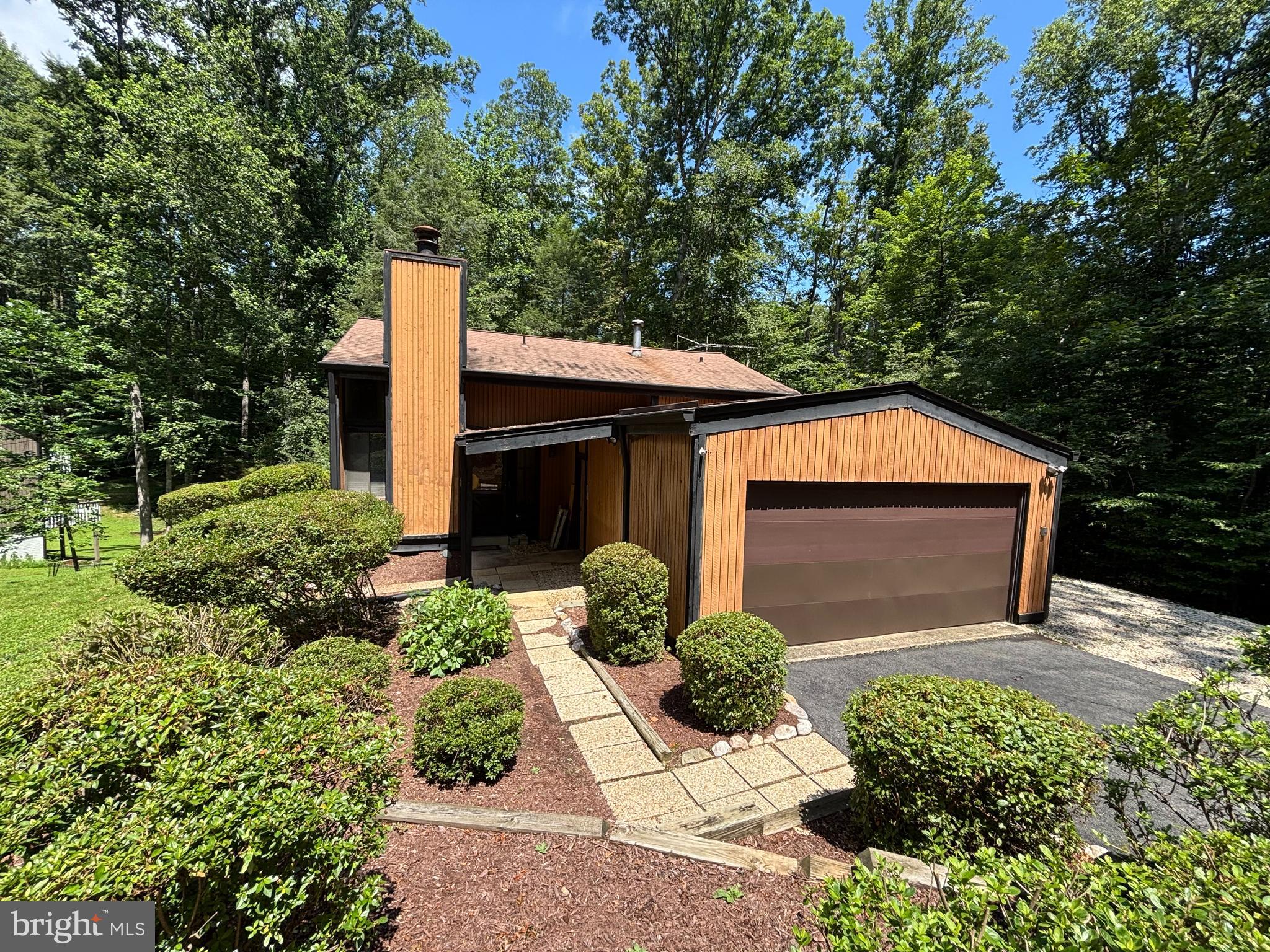 Welcome to your next home in the heart of Occoquan Forest—a one-of-a-kind community known for its wooded beauty, access to the Occoquan River, and a true sense of connection.
This contemporary split-level home offers a flexible layout with strong renovation potential. The main-level entry opens to a spacious living room with a soaring cathedral ceiling, a wood-burning fireplace, and floor-to-ceiling windows that fill the space with natural light. Just a few steps up, you’ll find the kitchen, dining room, full bath, and two bedrooms.
The walk-out lower level includes a third bedroom, a full bathroom, a laundry area, and another finished room—ideal for a home office, fitness area, or guest space. A shared closet accessible from both rooms adds convenience and flexibility.
While the home will need updating, it offers a great opportunity for the next owner to renovate and create something special in this peaceful, nature-filled community.
Additional features include a 2-car attached garage and ample parking on the paved driveway, offering plenty of room for vehicles and storage.
Situated on a little over half an acre, the property provides privacy, mature trees, and outdoor space to enjoy year-round. Step out onto the back deck and take in tranquil views of the surrounding forest—a perfect setting for relaxing or entertaining.
Residents of Occoquan Forest enjoy voluntary HOA membership for just $265 annually, with access to a private boat ramp, scenic hiking trails, a riverside pavilion, and community events—offering a lifestyle that feels like a weekend retreat every day.
Offered as-is, this property presents a great opportunity for renovation and long-term investment.