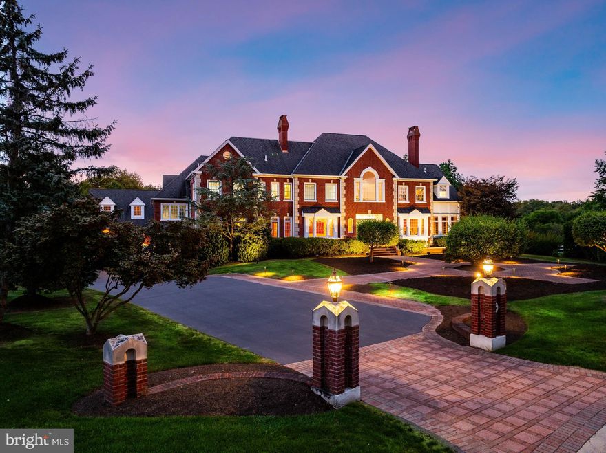 Welcome to “Willow View” — a timeless Georgian Brick estate perched on 2.04 lush, private acres in one of Blue Bell’s most coveted neighborhoods, Normandy at Blue Bell. With iconic curb appeal, manicured grounds, and commanding presence, this home is not only recognized—it’s remembered. Behind the classic façade lies over 11,000 sq ft of flexible living space across four finished levels—ideal for multi-generational living, serious entertainers, and car enthusiasts. A 4-stop elevator ensures seamless access. A generator and sprinkler system (on a private well shared with a neighbor—yes, it’s free!) offer comfort, savings, and peace of mind. Nestled on a quiet cul-de-sac, the home backs to 5 acres of HOA-owned land and borders 7 acres of preserved trails adjacent to a 100-acre equestrian estate—an ultra-private setting just minutes from Gwynedd Valley’s train, local trails, and Springhouse Shopping Center. Custom-built in 1995 and extensively renovated in 2012 with continued updates, Willow View welcomes you with a marble-floored foyer and sweeping curved staircase (think Gone with the Wind). Formal living and dining rooms offer gas fireplaces, while a richly paneled study and sunny four-season room provide flexible spaces to work or unwind. The chef’s kitchen features beaded inset cabinetry, Dacor 6-burner range, Sub-Zero fridge, double ovens, warming drawer, Wolf steamer, and two dishwashers. A large island with prep sink and refrigerator / freezer drawers adds function. The butler’s pantry—with Sub-Zero wine fridge and glassware storage cabinetry—leads to the formal dining room. A second, fully equipped catering kitchen just off the main kitchen boosts your entertaining power. A few steps up, a lofted “kids’ family room” with built-ins and a study nook offers added space. The vaulted main family room wows with 27-ft ceilings, Palladian windows, four sets of French doors, custom cabinetry, brick fireplace with gas insert, Sub-Zero beverage fridge, and a recently refreshed saltwater aquarium. Upstairs, the second floor includes four spacious bedrooms and a versatile bonus room. The primary suite features a gas fireplace, custom walk-in closet, and spa-like bath with vaulted ceiling, jetted tub, steam shower, radiant heat, and towel warmer. A Jack-and-Jill suite and private en-suite with loft (and built-in desk) ensure everyone has space to spread out. The bonus room is ready to flex—office, playroom, fabulous closet, additional bedroom or retreat. The third floor offers a guest suite with full bath and oversized bonus room currently set up with a large platform for model trains or slot cars. The lower level is a true destination: full kitchen, dual-shower bath, gym, 1,200+ bottle wine cellar with new mahogany racks, cozy den with wood-burning fireplace, and custom theater with Runco projector, Stewart screen, stadium leather seating, acoustic panels, and its own HVAC. Billiards, arcade games, and more (negotiable) complete the space. A whole house central vac system, laundry chute, distributed audio system, state of the art camera and security system, and a holiday window lighting package enhance the home's functionality. All 73 of the double-hung windows have recently been replaced. Outdoors, enjoy a heated pool and spa with waterfall surrounded by mature landscaping. The driveway offers ample surface parking for 4+ cars and two basketball goals for full-court play. The 5-car garage setup (3-car attached + 2-car with breezeway access) is a dream for collectors—add lifts (as currently installed) and you’ve got 7-car capacity. Unfinished space above the 2-car garage could become a studio or office. All within the top-ranked Wissahickon School District and easily accessible to the major local and regional highway corridors. At Willow View, you're not just buying a home—you're elevating your lifestyle.