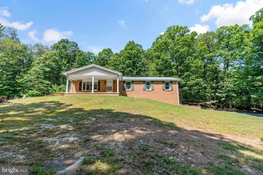 Well-built brick home with 4 bedrooms and 1.5 bath. Many improvements have already been completed, with new LVP flooring, the Metal roof installed only a couple years ago.  Central air a few years old and master bath has had some updates.  House is very livable while doing other upgrades if you desire.  Check out the beautiful hardwood flooring in dining area and living room with a fireplace. 2 car garage which leads into the basement where there is a countertop and sink with running water and another large room that can be a family room, man cave, office, or just storage.  Outside is a large detached 24 x 28 one car garage and workshop.  Nice woodshed and a 2-story building with 24 x 12 open room that has been wired and just waiting for your personal touches to make this a great space. and the bottom has a concrete floor with a root cellar in the back.  The house is equipped with a transfer switch in case of loss of power for you to hook up your generator. Only about 20 mins from downtown Berkeley Springs.