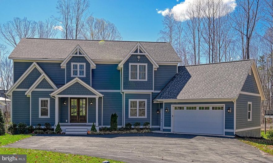 Welcome to this IMMACULATE 6-bedroom, 5.5-bathroom Contemporary Craftsman—a breathtaking custom-built retreat by Starwood Homes. Spanning 5,719 sqft with an oversized 2-car attached garage, this home has an expansive 270ft of water frontage in the sought after deep waters on the public side of Lake Anna and is being sold FULLY FURNISHED!
Nestled in Anna Vista II, enter through mahogany double doors into a stunning two-story foyer with a modern chandelier and engineered plank hardwood flooring that flows throughout the main level. The gourmet kitchen is a showstopper, designed for both beauty and functionality, with recessed lighting, an oversized island with seating for 6, granite countertops, bar seating, a deep farmhouse sink, dual Samsung refrigerators, a KitchenAid wall double oven, and a six-burner Zline gas cooktop with a custom tile backsplash and 48” hood. Soft-close Atlanta Birch shaker cabinets with LED-lit glass display accents extend to the ceiling. Two Samsung dishwashers, a built-in microwave, and a massive walk-in pantry complete this space.
The dining room features exposed pine box beams and a triple window with full-height glass for breathtaking water views. A custom 12-seat kitchen table adds charm. The open-concept main level features the family room off the kitchen, boasting a ceiling fan, gas log fireplace with shiplap surround, custom built-ins, and two sliding glass doors leading to a vaulted covered deck with Trex decking and dual ceiling fans. The main level also includes a butler’s pantry with a wine fridge, ice maker, and wet bar—perfect for entertaining! 
The main-level primary suite is a private oasis with vaulted ceilings, wainscoting, large windows with water views, dual walk-in closets each with built-ins, and a spa-like ensuite with quartz dual vanities, a shiplap accent wall, frameless rainfall shower, and a black metal soaking tub. A powder room, laundry room with built-ins, and garage access complete this level.
Upstairs offers three spacious bedrooms, including an alternate primary suite with recessed lighting, a ceiling fan, an ensuite bath with dual walk-in closets (one with a hidden bonus closet – perfect spot for a Murphy door!), dual vanities, and a frameless walk-in shower. Each bedroom has walk-in closets, ceiling fans, and private ensuite baths. A cozy second-story reading nook adds to the charm, featuring crown molding, two built-in bookcases, an adorable built-in bench seat with a large window overlooking the water, and mounted reading lights.
The walkout lower level is built for entertainment, featuring luxury vinyl tile flooring, a second full kitchen with stainless steel appliances, navy shaker cabinets, and quartz countertops. A large recreation room with recessed lighting and a pool table, a game room with shuffleboard and foosball, two bedrooms (one where you can easily add a closet), a full bath, a storage room, and a den complete the level. Step outside to the expansive patio leading to a personal beach with an irrigation system.
The 42’x44’ boathouse includes two PWC slips (30’x10’ and 26’x10’), a dry bar, storage, a covered deck, and a sun deck.   Extensive tree removal and landscaping has already been completed for you and provides unobstructed water views! For peace of mind, the home features three security systems detecting motion from people and animals, three HVAC zones (including a split zone for separate temperature control in the main living area and primary suite), two retaining walls, and high-speed internet at both the house and boathouse with a point to point connection.
Did I mention this luxurious lakefront home features frameless windows and sliding glass doors to maximize natural light and uninterrupted water views? Every detail has been thought of and don’t forget it comes FULLY FURNISHED—schedule your private showing today! Take a sneak peek with our 3D iGuide Tour!