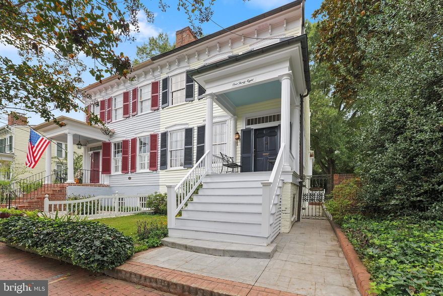 A rare offering in the desirable historic riverfront neighborhood, Lower Caroline Street. This well-maintained Greek Revival Style TH/Duplex was built around 1855, and sits on a 5600 sq ft fenced-in lot w/landscaped rear and side yards. This gracious home has 3 finished levels, with over 2600 sq ft of finished living area and echoes the quiet elegance of the original homes on Caroline St.  From the columned front porch, step into the foyer through double leaf louvered exterior doors and a stately wood paneled front door with side lights and transom.  The main level with 10’ ceilings has a living room and dining room with original fireplaces, sitting area in an addition built circa 1970, and a modern kitchen (added in 2005) along with a powder room. The kitchen is designed with stainless steel appliances, slate floors and hand-crafted maple cabinets with a matching rolling island.  The sitting area, with antique pine panelling and corner cupboard,  is perfect for casual entertaining, with sparkle added by the vintage stained glass panels in the kitchen transom and sitting room window.  The original heart pine floors throughout the home have been very well preserved. Most rooms have crown moldings and chair railings, and built-ins include book cases, display shelving and cabinets.  Six over 6 windowpanes have been preserved.  A handsome staircase leads to the upper level and two bedrooms, each with a fireplace, crown molding, chair railings and over-mantel molding.  The full bathroom on this level has mosaic tile flooring, and a vintage buffet for the sink. The rear facing bedroom has decorative 18th c. tiles on the mantel and preserved Civil War graffiti!  The lower level is a Raised English Basement that can be accessed from the foyer on the main level or via its own exterior entrance.  It was fully renovated in 2003, with beautiful ceramic tile flooring throughout, and features a den and a bedroom, both with original fireplaces, a full bathroom and kitchenette, and a laundry area with shelving and front-loading washer and dryer.  A spacious, sun-filled office faces the rear and side yards, with custom cabinetry built in 2006 (desk, cabinets, shelving and seating area) along with replacement exterior door and windows.  The sidewalk leading to the English basement entrance was rebuilt in 2006.

The house was extensively renovated (including electrical system and plumbing) but always with care to protect the historic character and elements such as plaster walls, wood floors, paneling and vintage glass.  In 2003, plaster and paint were repaired on the main floor, and new fixtures installed in the powder room.  The exterior front steps were upgraded using mahogany wood. Plaster and paint repair continued on the second floor in 2004, and new floor and wall tiles, vanity cabinet and decorative lighting were installed in the bathroom.  Renovations continued into 2005 with the kitchen addition, and a new standing seam roof was built over the rear of the house (sitting room, kitchen and rear entrance foyer). In 2006, the stamped concrete walkway was added, and all gutters replaced, with copper gutters put in the front of the house.  In 2007, a new standing seam roof was installed on the front part of the house, with added insulation and attic decking.  Other improvements:  a new gas line to the house from the main (2010); 100 years of paint stripped off the front columns to reveal the historic carved wood and porch railing refreshed (2011); updated electrical panel box (2011) and surge protection added (2013); new hot water heater (2015).  Ext regular painting every 6 yrs.  Recently painted June 2024. 
This property is easy walking distance to VRE, Amtrak, the Rappahannock River, the new Riverfront Park, and Historic FXBG where dining, shopping and entertainment are at your fingertips. This elegant home won't last! Schedule your tour today!