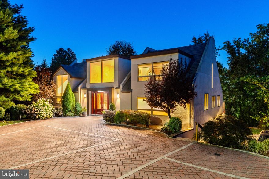 Tucked away within one of the Main Line’s most beautiful neighborhoods, this architecturally significant contemporary , originally inspired by acclaimed architect Hugh Newell Jacobsen , stands out as a unique rare modern gem among Gladwyne’s traditional estates. Known locally as the former “Glass and Cedar House,” the residence retains its striking form while benefiting from contemporary updates. As you arrive, the detailed brick driveway, manicured landscaping, and distinctive design immediately set the tone for this exceptional home.
Inside, soaring 20-foot ceilings, walls of expansive windows, and multiple sliders bathe the interiors in natural light and create a seamless connection to the surrounding greenery. The restaurant-style kitchen is a chef’s dream, appointed with Wolf and Sub-Zero appliances, gas cooking, a wine refrigerator, trash compactor, built-in espresso and coffee maker, a stunning 19-foot quartz island, and Caesarstone countertops - perfect for cooking, entertaining, and gathering. The welcoming first-floor entry features a stunning view with high ceilings and sky lights and is flanked by a large closet and a perfectly placed powder room.
The 3-bedroom, 3.5-bath layout offers both versatility and modern comfort. The spacious first-floor primary suite features a private balcony overlooking the grounds, two generous closets, and an inspiring loft area ideal for a home office, gym, or nursery. The spa-like bath is complete with a soaking tub, radiant heated floors, a high-end Japanese toilet, and an oversized glass shower. A striking floating staircase leads to the lower level, where you’ll find two additional bedrooms with hardwood floors, two updated full bathrooms, a dedicated laundry and utility room, and a sunken family room with access to the back patio. Every window frames tranquil, tree-filled views, enhancing the home’s retreat-like atmosphere.
Additional highlights include a gas fireplace, built-in speakers throughout, dark-stained hardwood floors, landscaped front grounds with Coventry walls, EP Henry stonework slate steps and a deck that runs the entire length of the back of the house overlooking the this beautifully landscaped property . Just minutes from the Schuylkill River, top-rated Lower Merion schools, Philadelphia Country Club, and major highways to Center City and King of Prussia, this one-of-a-kind property offers architectural pedigree, privacy, and a move-in-ready modern lifestyle.