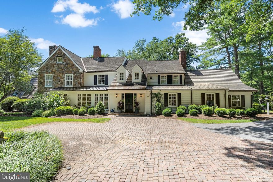 A luxurious, scenic retreat in the heart the Main Line, this completely renovated, modern stone farmhouse boasts breathtaking views at every turn. The current owners went to extraordinary lengths to update nearly every inch of the property with high-end, tasteful amenities and finishes designed to complement the home’s spectacular year-round vistas. Inside, a welcoming two-story foyer with gorgeous curved staircase provides a gracious entry point to the expansive first floor, which features hardwood floors throughout, neutral paint, endless windows, designer light fixtures and a state-of-the-art Lutron® lighting control system. Down the front hall sits a sun-drenched dining room with exquisite custom glass cabinetry and an oversize window framing the beautiful countryside beyond. The dining room connects to a renovated designer kitchen with center island, white inset cabinetry, quartzite countertops, Subzero® custom-paneled refrigerator and Thermador® 48” gas range. The kitchen also boasts a walk-in pantry with appliance station and French door access to the rear stone terrace. Adjacent to the kitchen you’ll find a generously sized family room with custom moldings and built-ins, plentiful windows and a gas fireplace. A large cased opening leads to the glorious sunroom with heated slate floor, beamed sky-lit ceiling, custom cabinet with built-in wine and beverage fridge and panoramic views of the home’s rolling acreage. A graceful living room with gas fireplace, renovated powder room and a bright office with custom built-ins complete this spectacular first floor. Upstairs, the glorious primary suite includes every upgrade and amenity imaginable, from a separate sitting room with window seat and custom built-ins to designer walk-in closets. The enormous ensuite bath features a soaking tub perched beneath a grand arched window, separate vanities, water closet, heated floors and an oversize marble-tiled shower with bench seating. The primary suite also boasts a convenient rear stairway that leads directly to the first-floor office. On the other end of the second floor, you’ll find a renovated hall bath and two large bedrooms—one with a renovated ensuite bath and another with an ensuite bonus room. The third floor houses another bedroom with renovated full bath and separate lounge area. Downstairs, relaxation and rejuvenation await in the soaring, window-lined pool house with beamed ceiling and stone accent wall. Here you’ll find an indoor pool with lap lane, hot tub and ensuite full bath with sauna and changing rooms. From the pool area, a glass door leads to a new kitchenette and lower-level finished rec room. Outside, the home’s six acres of picturesque grounds include a wraparound, tiered stone terrace and a tennis and basketball court. A detached three-car garage includes a newly finished loft with full bath and kitchenette that could easily serve as a home office or au-pair suite. Located in Easttown Township and zoned for top-rated T/E School District, this majestic home is minutes from downtown Berwyn and Paoli, along with several premier private schools and Main Line destinations.