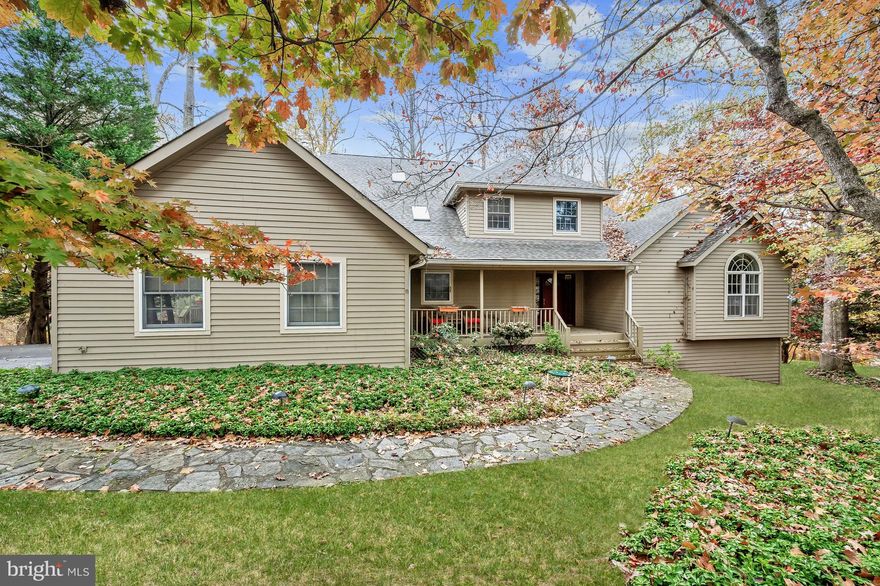 Spacious home on over 1 acre backing to woods and located on a quiet cul de sac in sought after Ellicott City. This home boasts 3 finished levels with over 4,500 sq. ft. of living space, a walkout lower level, a huge, screened porch, high vaulted ceilings, and multiple skylights allowing abundant natural light.  Enter from the covered front porch to the sun filled two story foyer highlighting hardwood flooring and arched doorways embellished with decorative trim leading to the living and dining rooms.   The eat-in kitchen includes a breakfast nook with deck access, a center island with a gas cooktop and prep sink, and abundant storage and counter space.  Relax by a cozy fire in the off-kitchen family room that offers a custom-built workstation, and access to the screened porch.   Conveniently located is the entry level primary bedroom suite that includes two walk-in closets, a vanity dressing area, and en suite bath with a jetted tub, separate shower, and dual vanity.  Ascend the staircase to find three sizable bedrooms, one with a cozy fireplace and private balcony, and a sun filled bonus room with a skylight.   You’ll love entertaining in the walk out recreation room embellished with a stacked stone, see-through fireplace to a game area, and a custom wet bar that includes a mini fridge, dishwasher, and electric cooktop.  Perfect for overnight guests is a bedroom suite with a walk-in closet and adjoined full bath.  There’s a large storage room and closet with built in organization system.  Enjoy outdoor living on the large, screened porch, open deck, and shaded patio admiring serene, wooded views.